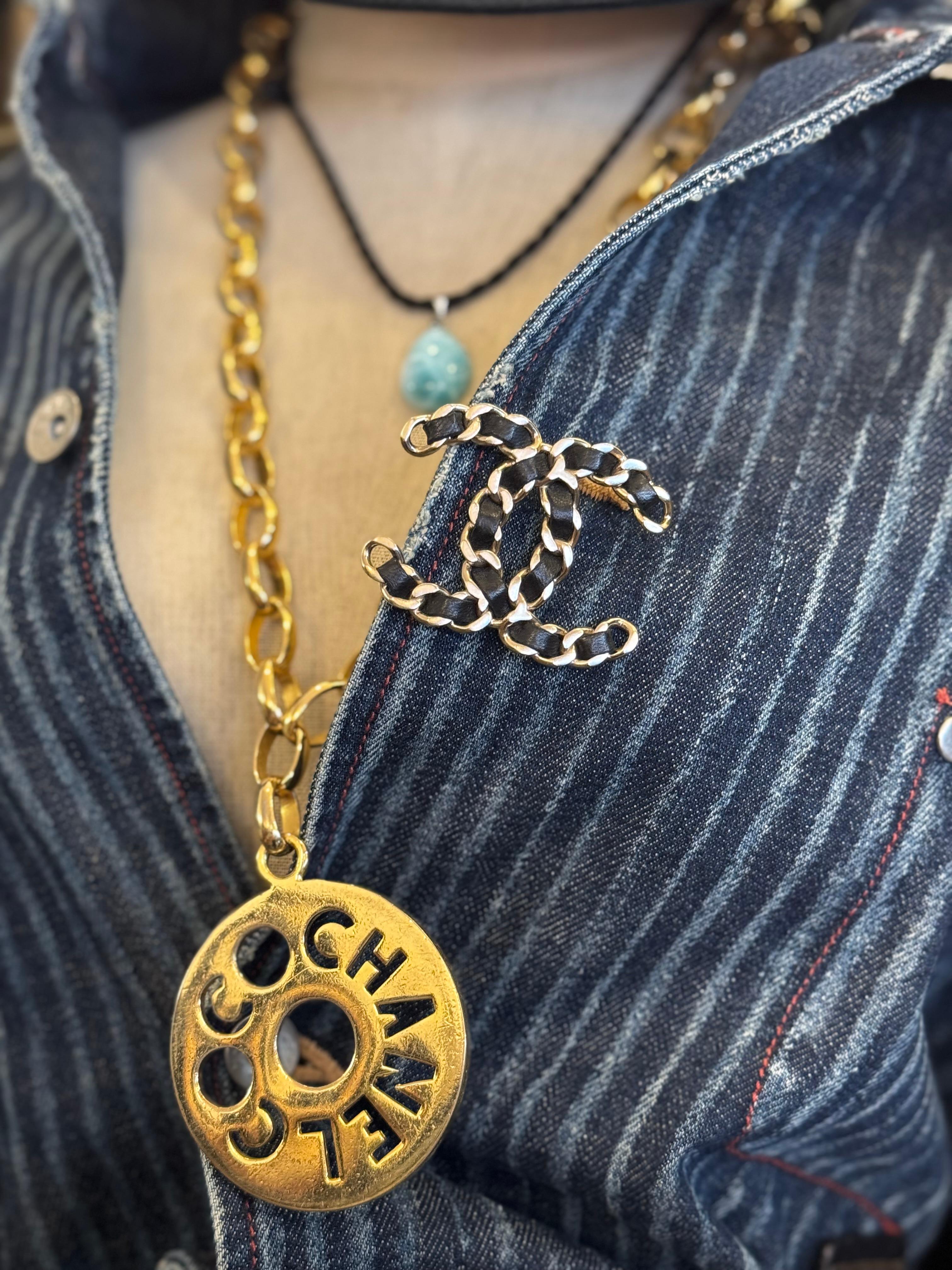 This CHANEL CC brooch is crafted of matte silver toned metal chain interlaced with black leather. Stamped CHANEL 16 B made in France. Measures approximately 5.5 x 4.3 cm. Comes with box. 

Condition: Excellent pre-loved condition with minimal to no