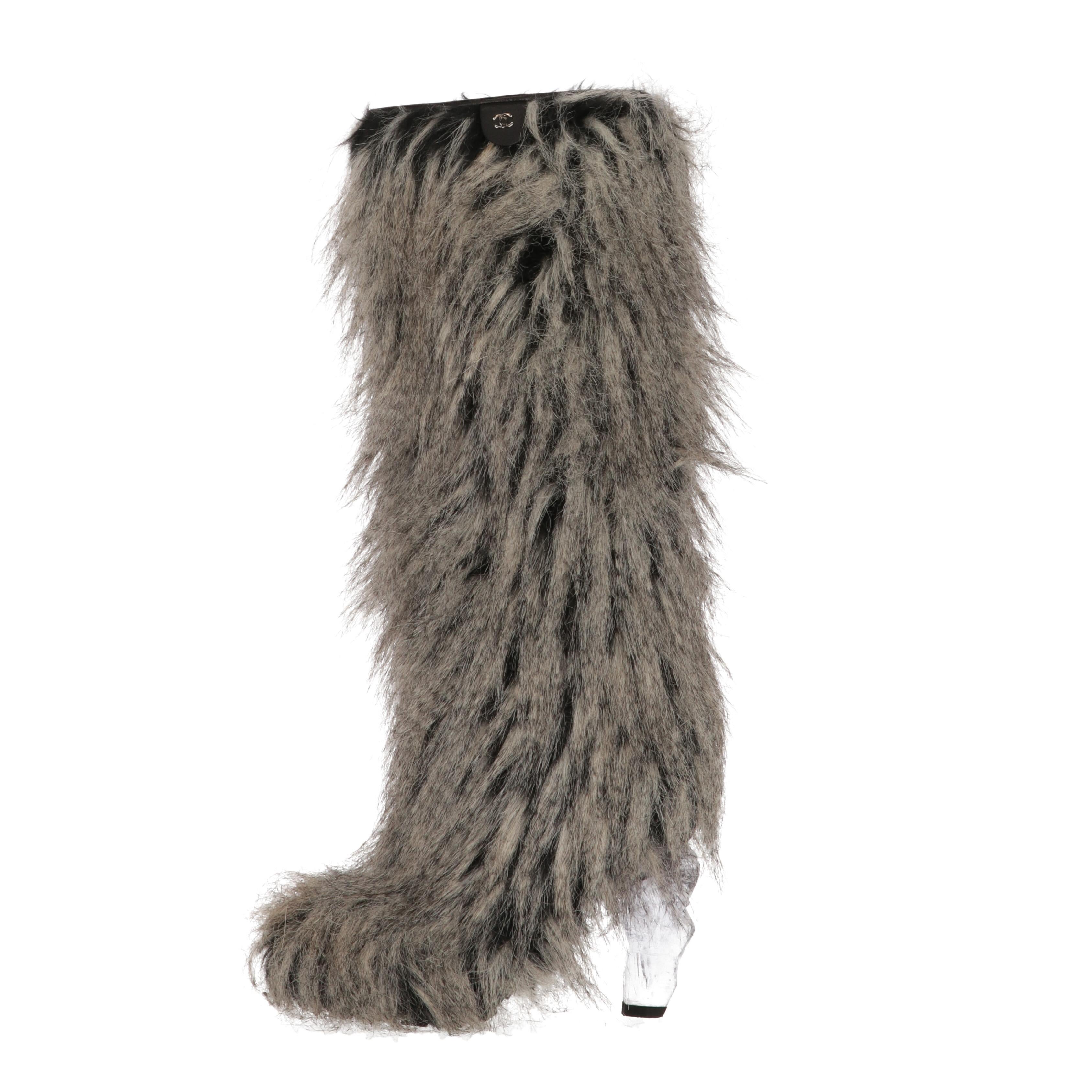 Chanel grey and black faux fur boots, with hidden side zip and the one of a kind transparent plexiglass icicle heel. They features a black genuine leather label with silver-tone metal CC iconic logo on the top. Leather edging and lining.

The right