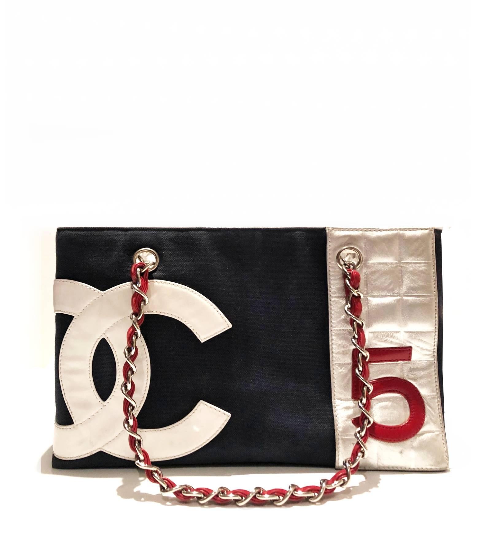 Ungewöhnliche Chanel No 5 Tote Bag:: aus marineblauem Segeltuch und Leder mit silberfarbenen Schulterketten und einer offenen Oberseite:: mit einem metallisch-silbernen Innenraum und einer Innentasche mit Reißverschluss

Zustand: gut:: im Einklang
