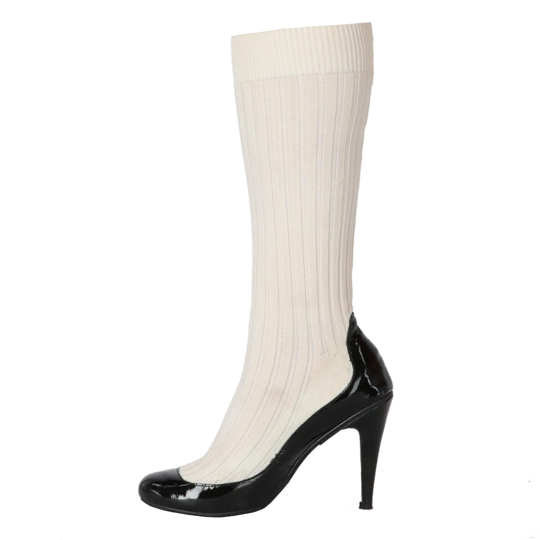 Chanel mid-calf length patent sock boots, featuring black patent leather pumps and merged knit ribbed white socks. Round toe, high heel and little CC signature glued on the back of the shoe.
They shows very little signs of wear on the sole, as shown