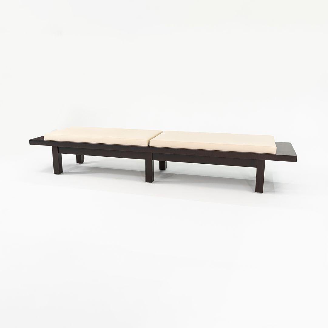 This is a Cordovan Wooden Bench, designed by Christian Liaigre for Holly Hunt. The listed price includes one bench, and we currently have two available for purchase. Their design features a thick boxy espresso brown wood base, and has cream leather