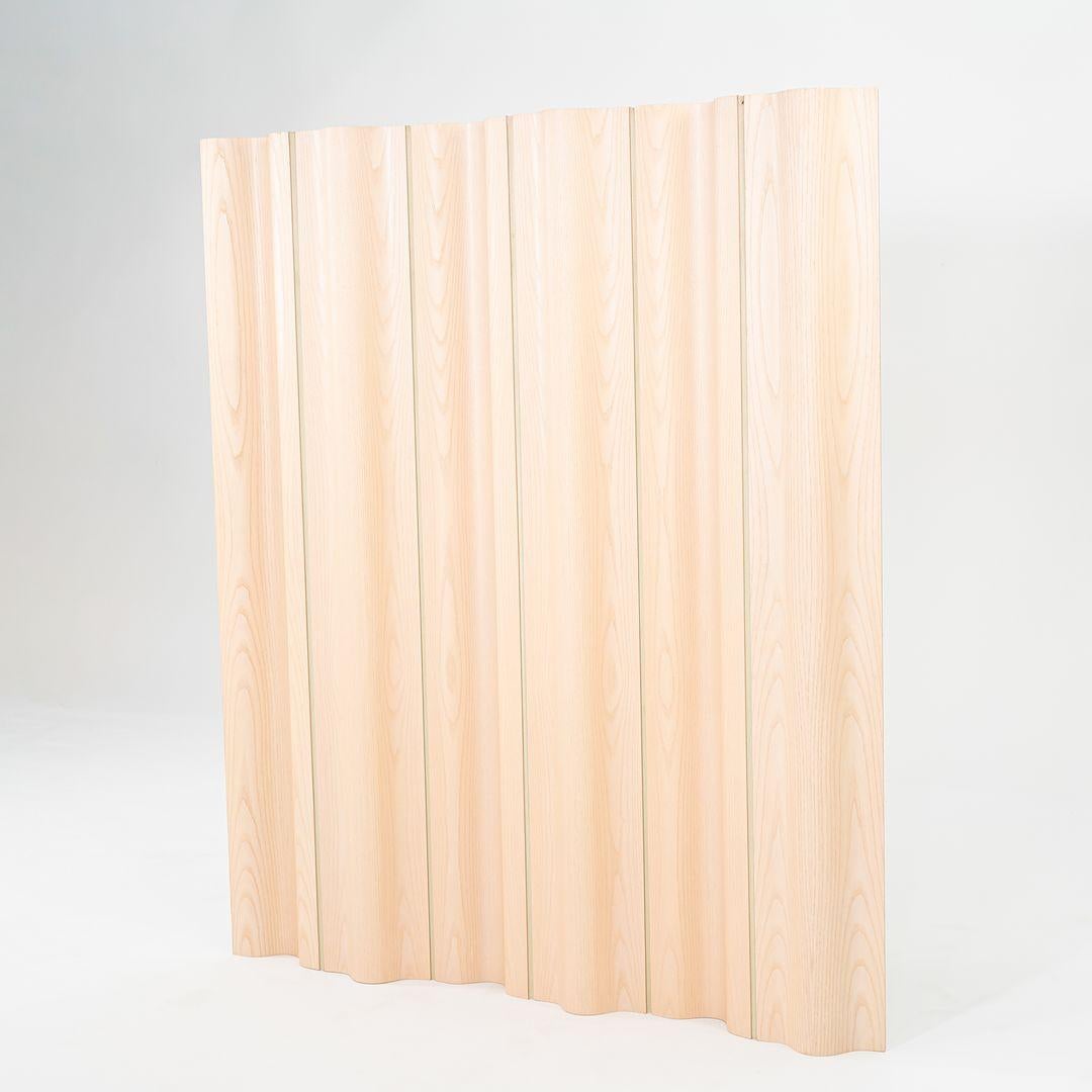 This is an Eames Molded Plywood Folding Screen, originally designed by Ray and Charles Eames in 1946. This particular example was produced by Herman Miller in the USA in the 2010s. The folding screen is comprised of molded white ash plywood panels