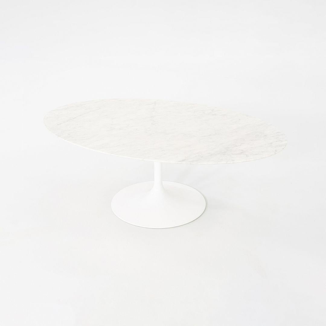 This is a Tulip Coffee Table, originally designed in 1956 by Eero Saarinen for Knoll. This particular piece was produced in the USA in the 2010s. The table features an aluminum base that is coated in a white polished finish. Its top is made of
