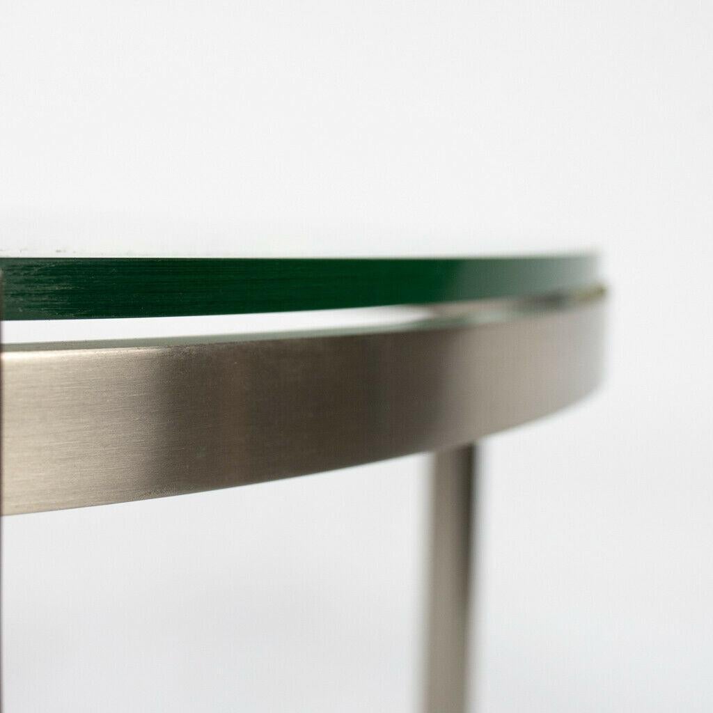 Listed for sale is a Metal Series side table produced by Geiger. This is a gorgeous example, which was constructed from solid stainless steel, given a matte finish, then paired with a tempered glass top. The table is in very good to excellent