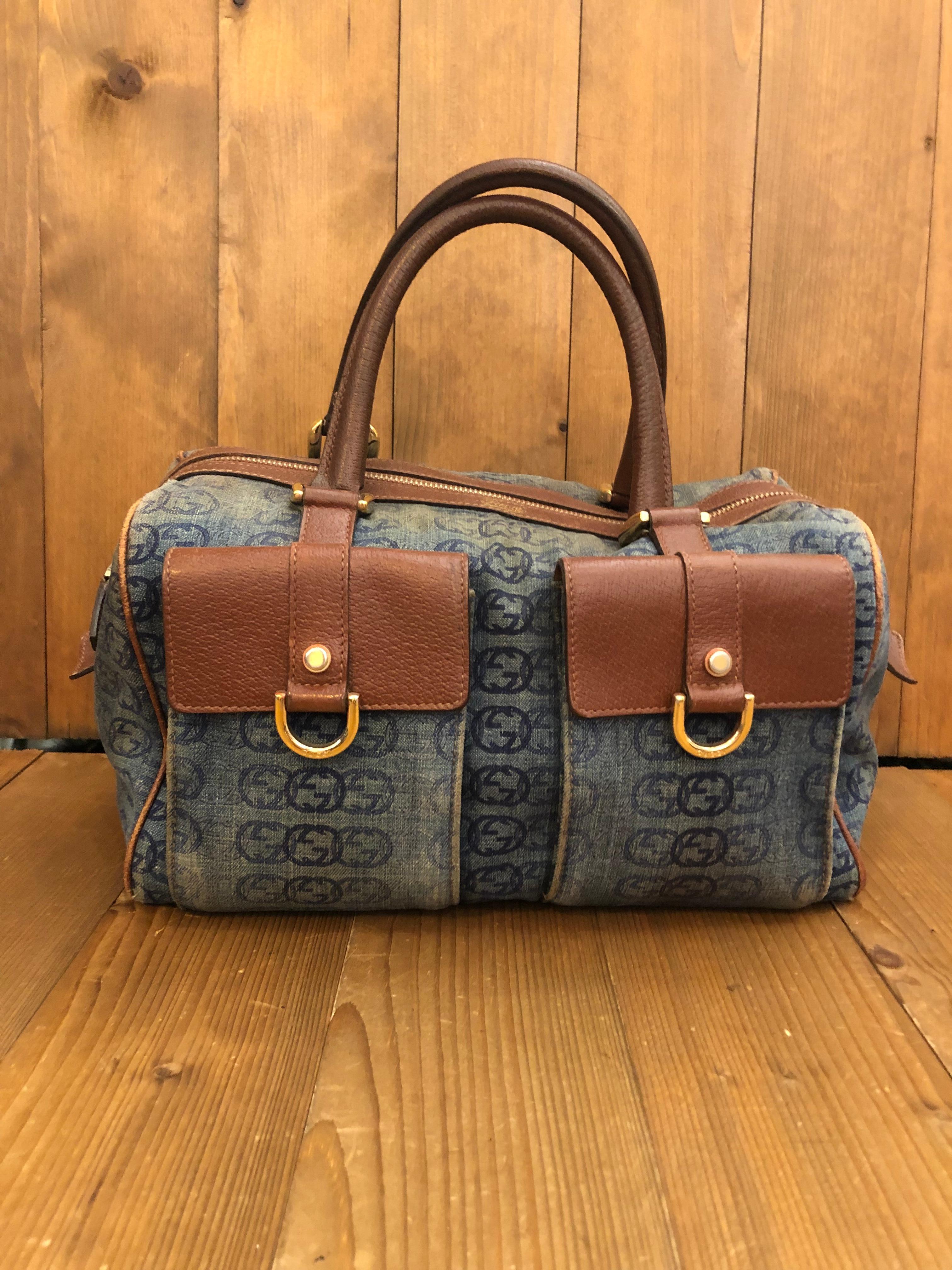 Este bolso vintage GUCCI boston está confeccionado con el monograma Gucci GG en tela vaquera azul y piel marrón con herrajes en tono dorado claro. El cierre de cremallera superior se abre a un espacioso interior de tela marrón con bolsillos de