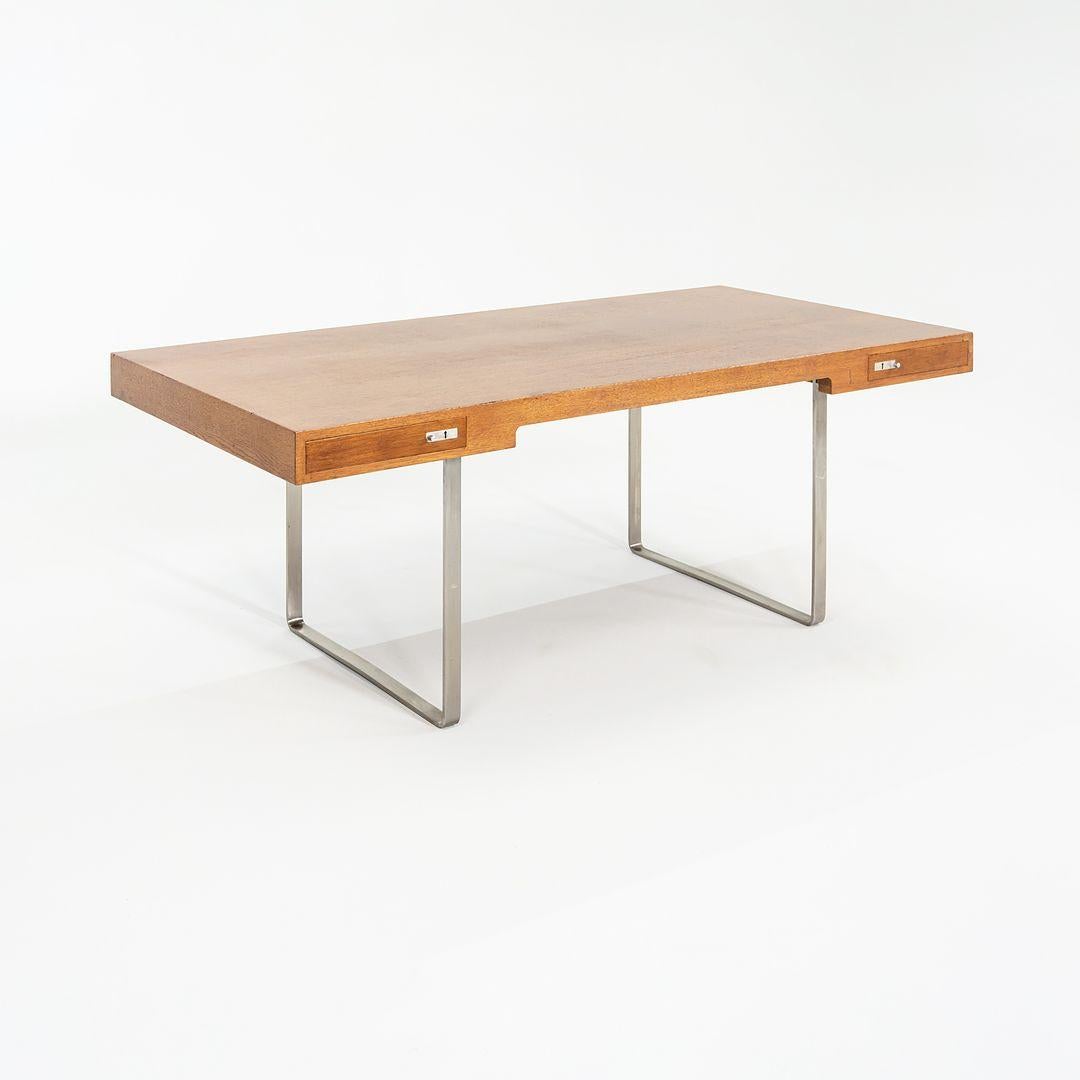 This is a CH110 Executive desk, originally designed by Hans Wegner in 1970. This particular example was produced by Carl Hansen in Denmark in the 2010s. The desk is comprised of both veneer and solid oak wood and stainless steel legs. 
 
 The CH110