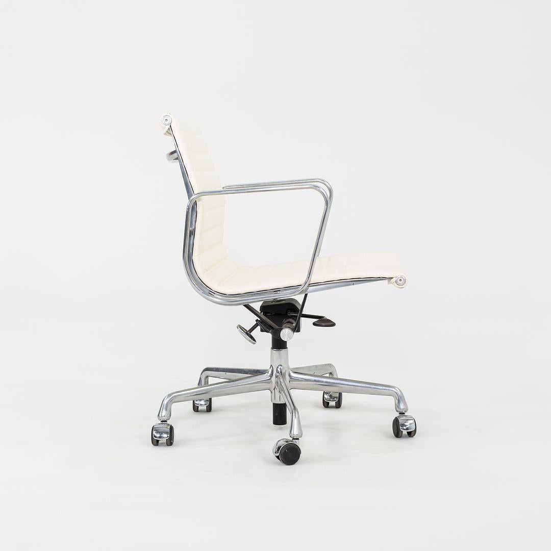 This is an Eames Aluminum Group Management Desk Chair, Model EA334, designed by Charles and Ray Eames for Herman Miller in 1958. This particular chair was produced in the 2010s. The design features a cast aluminum frame with a pneumatic adjustable