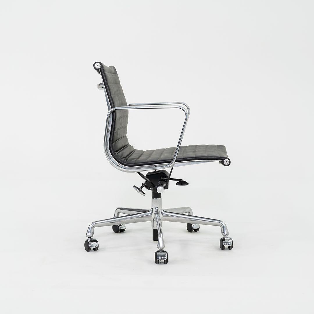 These are Eames Aluminum Group Management Desk Chairs, Model EA334, designed by Charles and Ray Eames for Herman Miller in 1958. These particular chairs were produced in the 2010s. Their design features a cast aluminum frame with a pneumatic