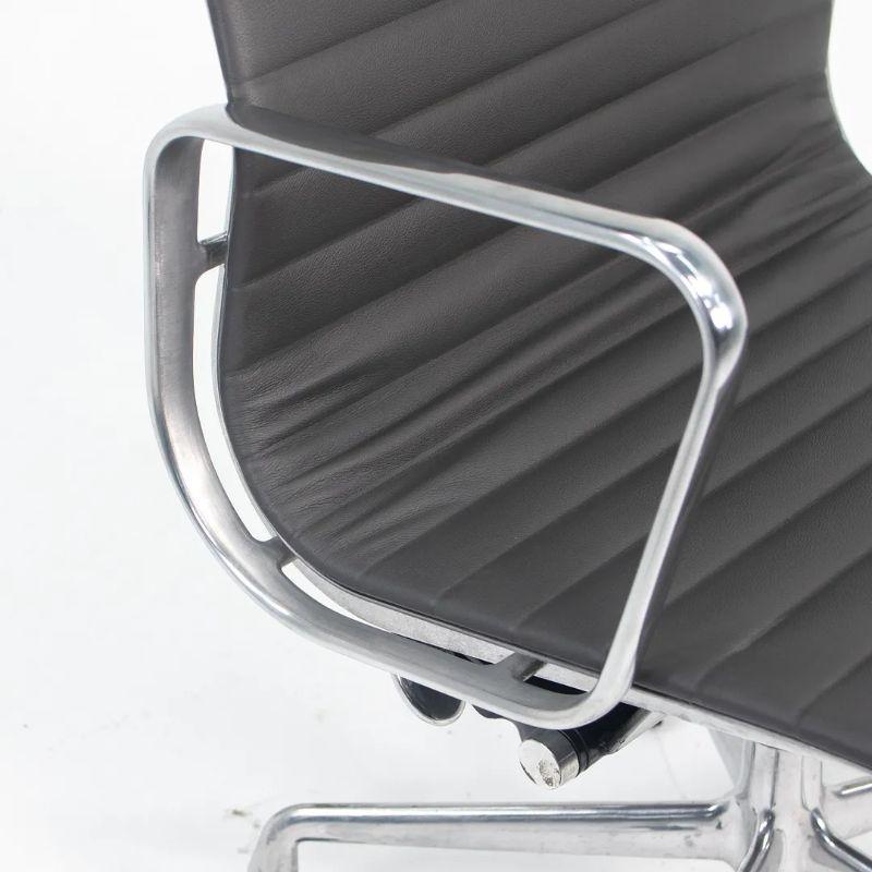 This is a single Herman Miller Eames aluminum group management desk chair in gray leather with polished aluminum base. The upholstery is very supple and in seemingly immaculate condition. There is some remnant dust on the back of the chair, which