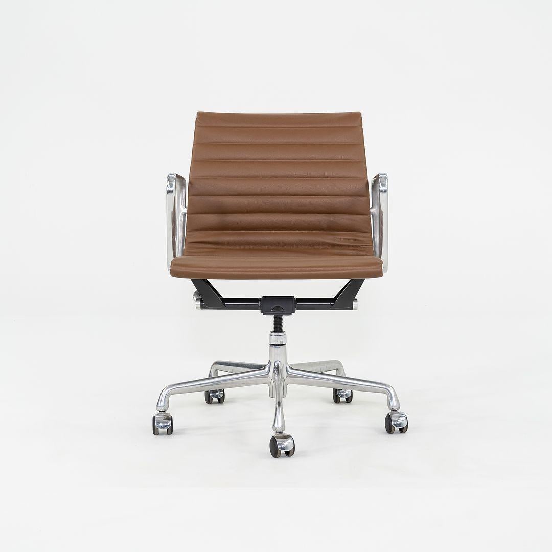 This is an Eames Aluminum Group Management Chair, originally designed by Charles and Ray Eames for Herman Miller in 1958. This particular example was produced in the 2010s. The design features an adjustable aluminum 5-star base with a 360-degree