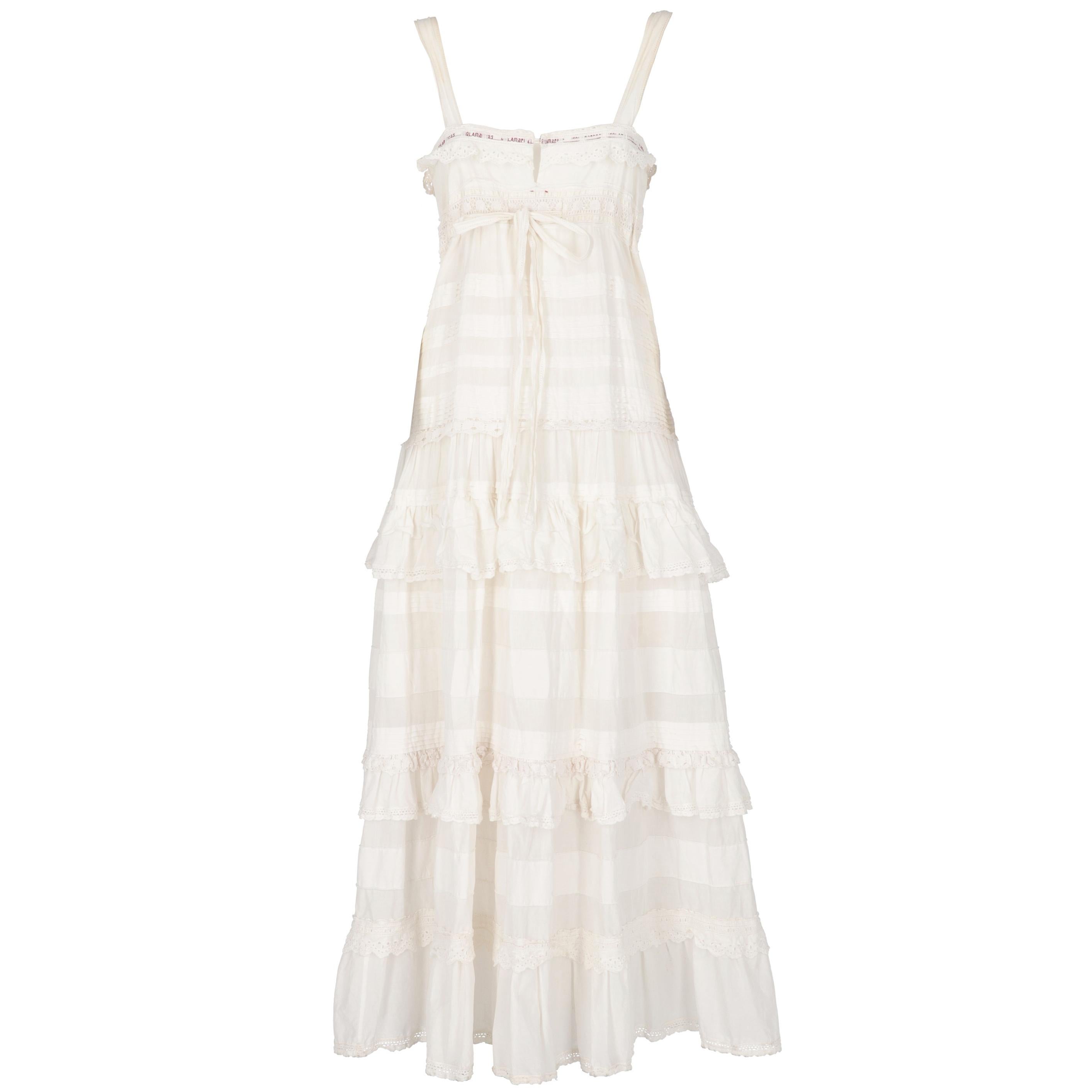 This lovely I'm Isola Marras by Antonio Marras white cotton long dress with shoulder straps features a zip and button front fastening, an original red embroidered branded drawstring on the chest and pleated inserts with crochet laces on the top. The