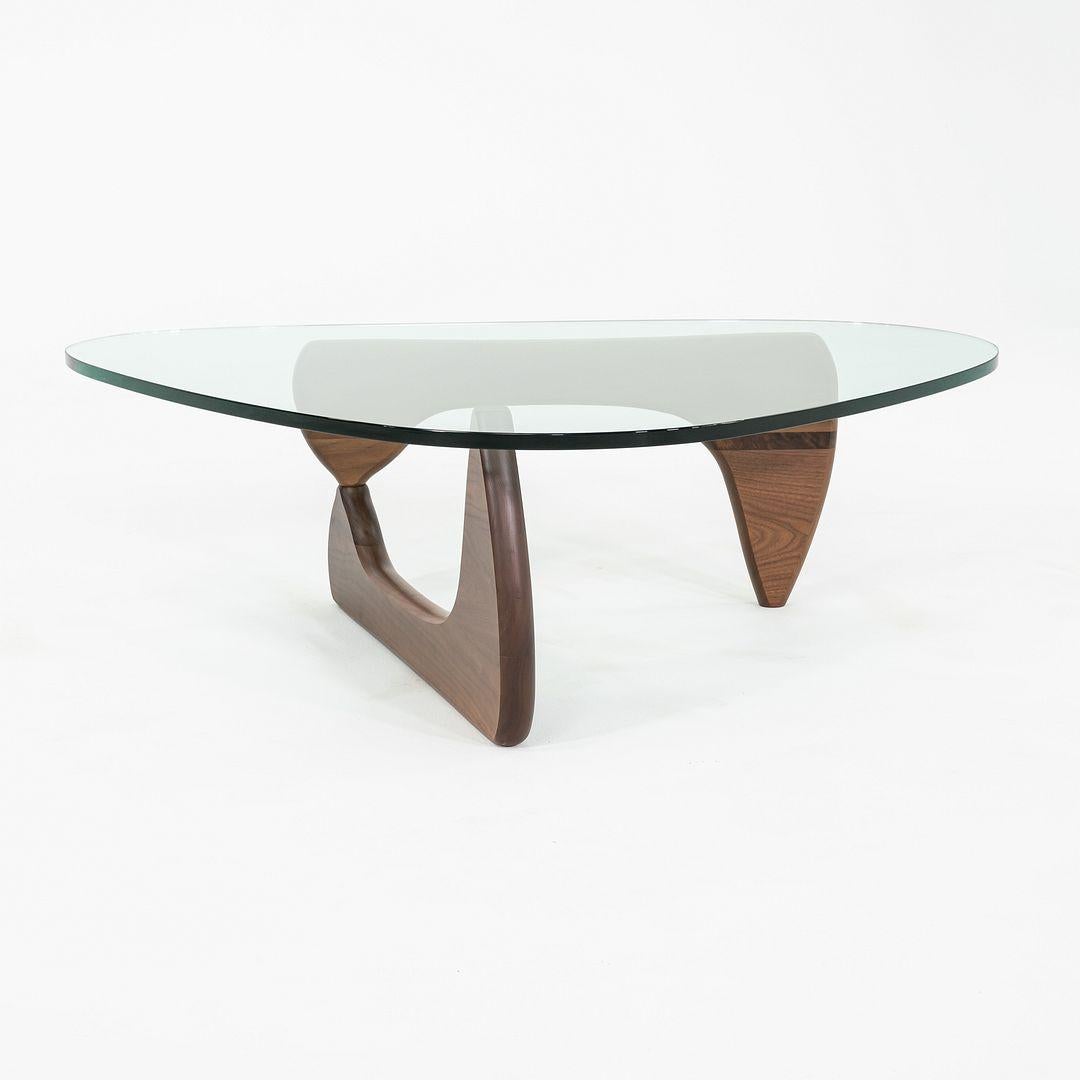 Dies ist ein Noguchi Couchtisch, der 1944 von Isamu Noguchi entworfen wurde. Dieses Exemplar wurde in den 2010er Jahren von Herman Miller in den USA hergestellt. Der Tisch besteht aus einem Sockel aus Nussbaumholz mit einer Tischplatte aus Glas.
