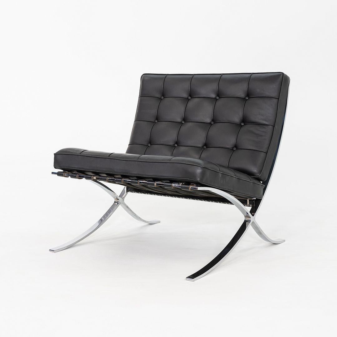 Il s'agit d'une chaise longue Barcelona, conçue à l'origine par Mies van der Rohe en 1929. Cet exemple particulier a été produit par Knoll dans les années 2010. La chaise est composée d'une base en acier chromé, qui porte une gravure de Steele, avec