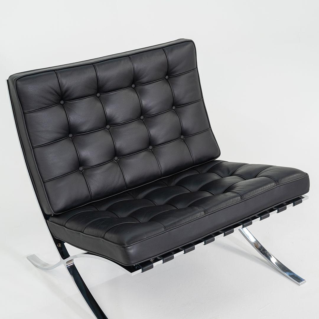 These are Barcelona Lounge Chairs, model 250L, initially designed by Mies van der Rohe in 1929. These particular examples were produced by Knoll in the 2010s. These chairs are comprised of chrome steel bases with cushions upholstered in black