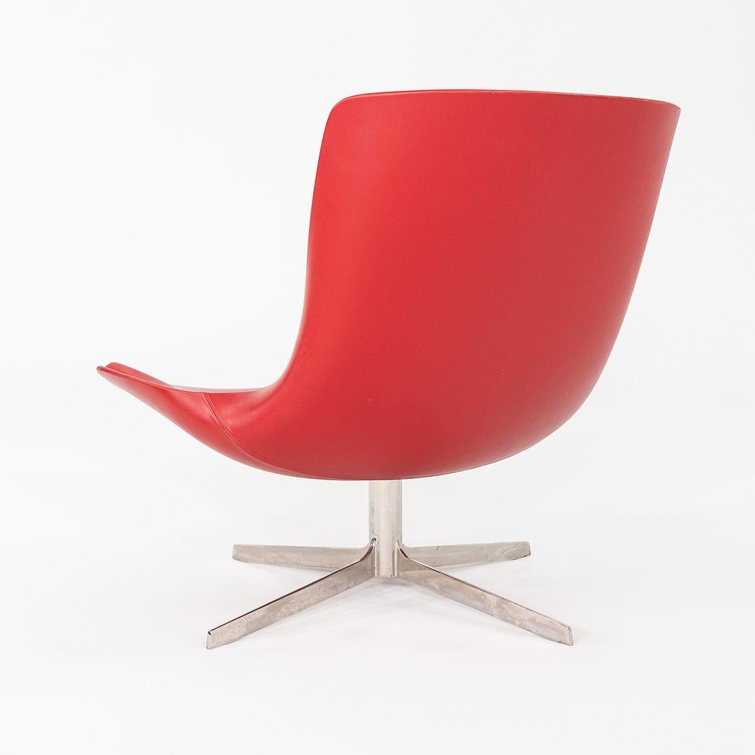 Esta es una Silla Lounge Giratoria Vika, diseñada originalmente por Monica Forster para Bernhardt Design en 2010. Estos ejemplares se fabricaron en la década de 2010. Su diseño incluye una carcasa de fibra de vidrio totalmente tapizada en piel roja,