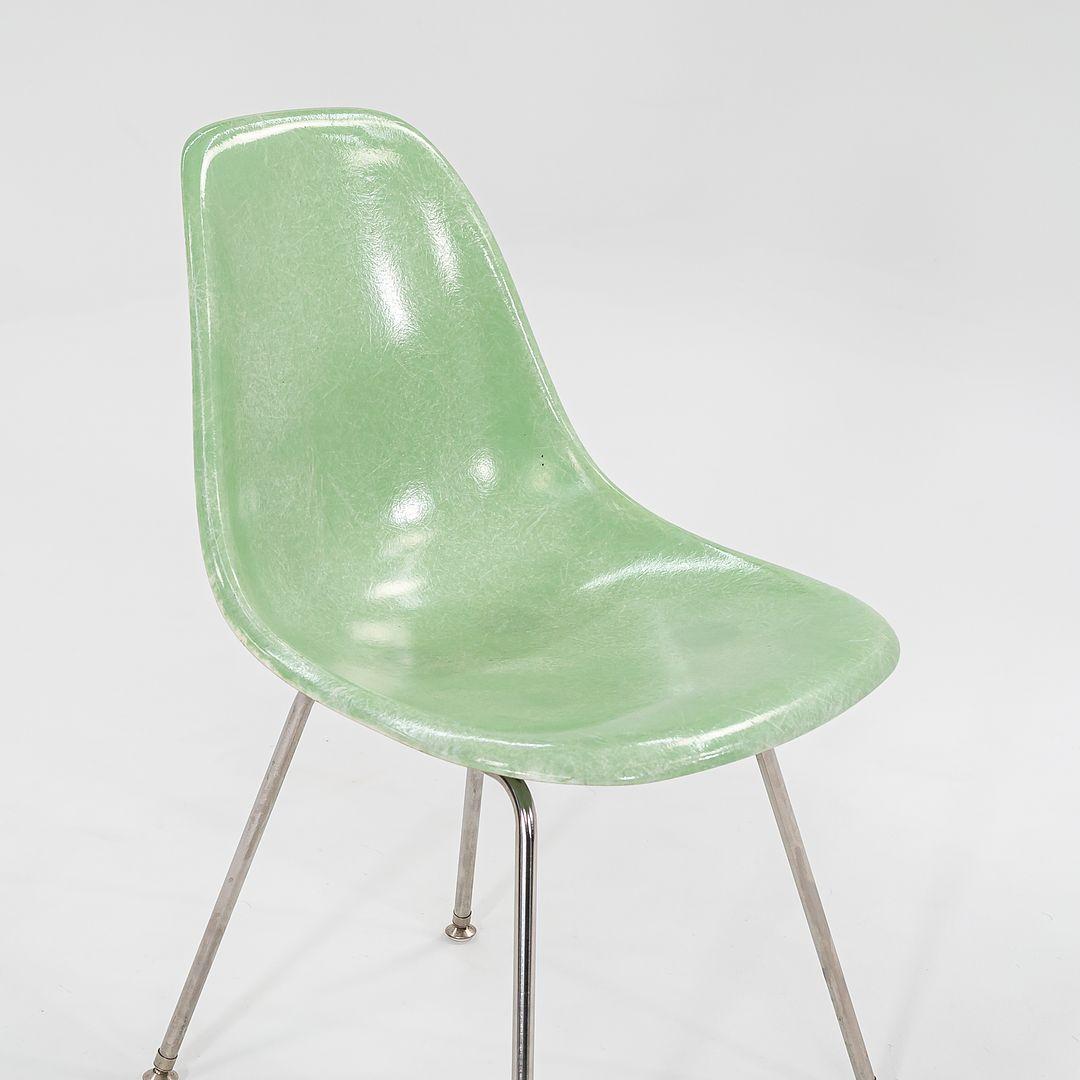 This is a set of four light green Fiberglass Shell Chairs with an H Base, made from chrome plated steel. Designed by Ray and Charles Eames, these chairs were produced by Modernica in Los Angeles, California in the 2010s. The listed price includes