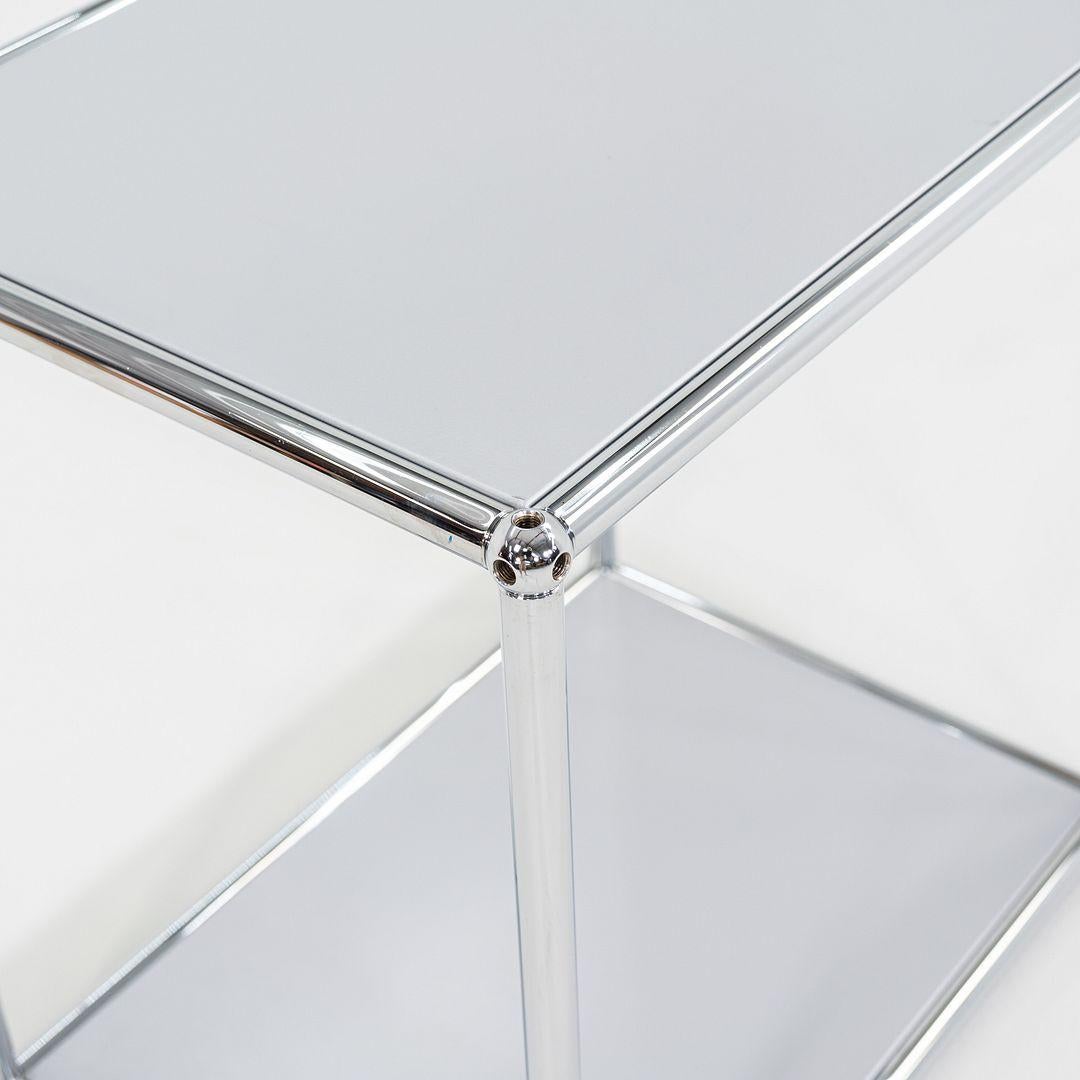 Il s'agit d'une table d'appoint USM Haller, conçue à l'origine par Fritz Haller et Paul Schaerer en 1963. Cet exemple particulier a été produit dans les années 2010. La table est composée de panneaux en acier recouverts de poudre d'argent mat et