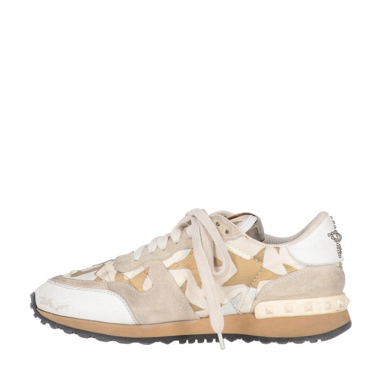 Valentino Garavani Rockrunner sneakers in leather, suede and fabric with white, ivory camouflage pattern and golden details. Rubber sole and metal studs on the back. It comes with box.

The shoes showed slight signs of wear, as shown in the