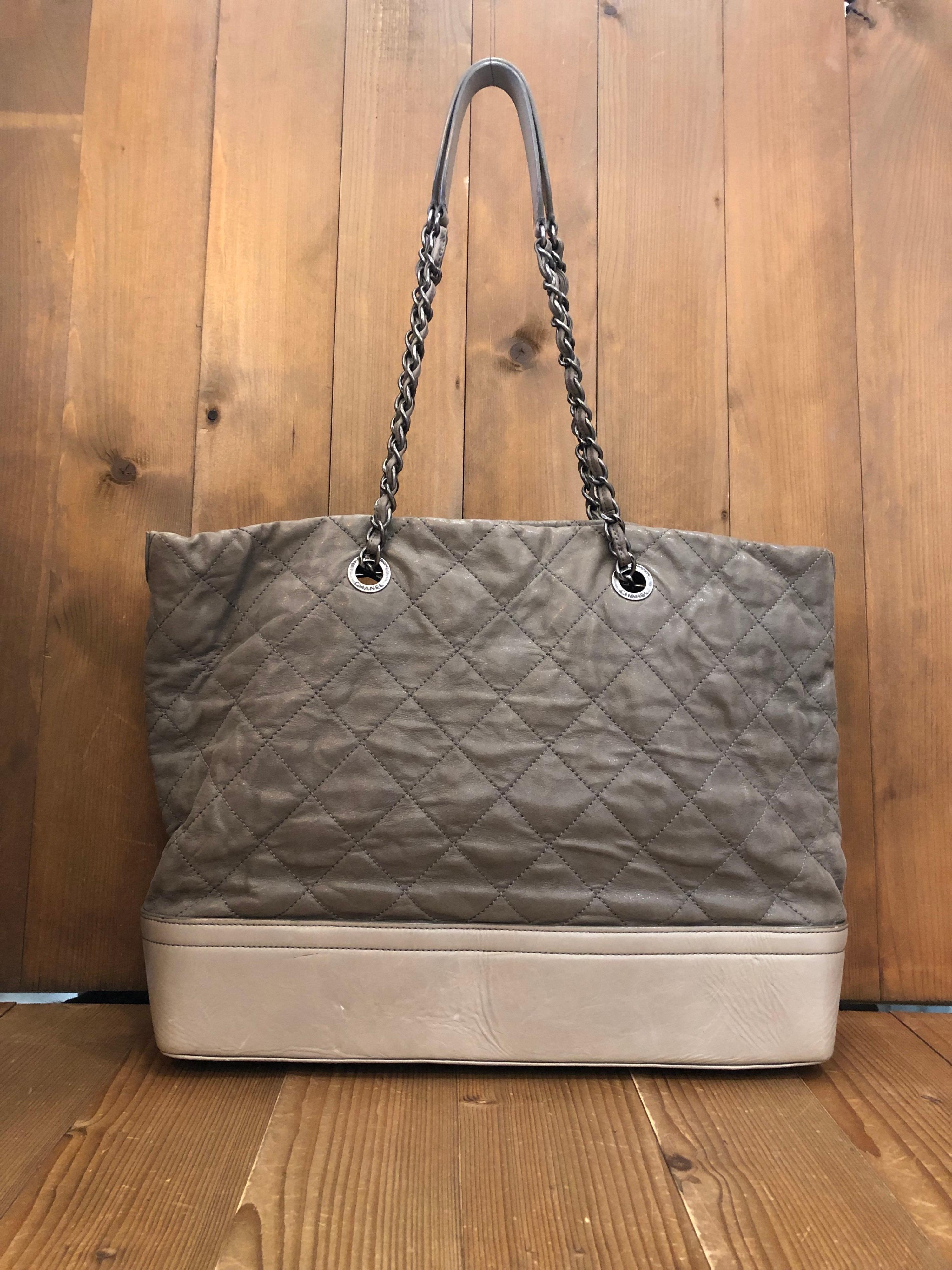 2011 Chanel XL chain tote in distressed khaki calfskin leather featuring one interior zip pocket and two interior open pockets. Detachable chain interlaced with the same leather. Made in Italy. Measures 18 (top) 14.5 (bottom) x 12 x 4.5 inches Drop