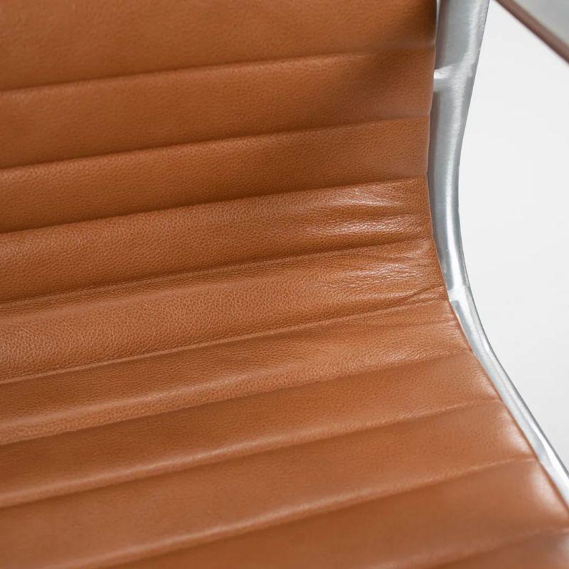 This is a single (the price listed is for one chair, though multiple chairs are available) Herman Miller Eames aluminum group management desk chair in caramel/cognac leather with polished pneumatic aluminum base. The chairs were produced in 2011.