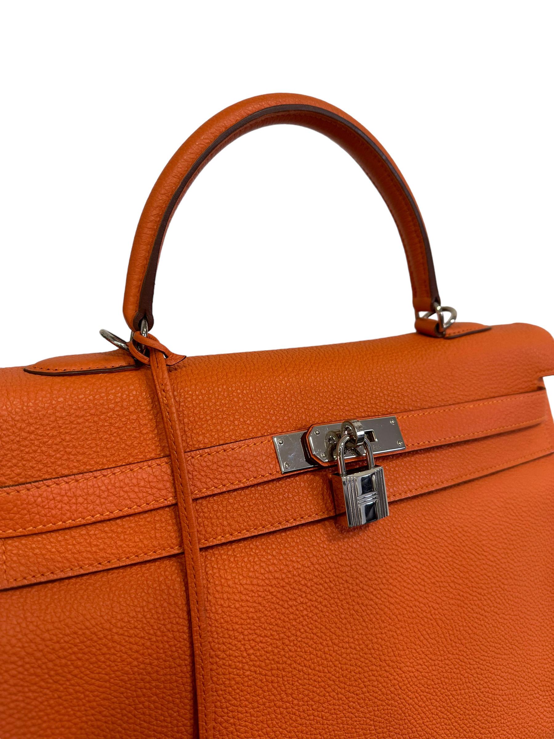 Hermès bag, Kelly model, size 35, made of orange fjord leather with silver hardware. Equipped with a front flap with Hermès twist lock, padlock and keys. Internally lined in smooth orange leather, complete with three pockets including one with zip