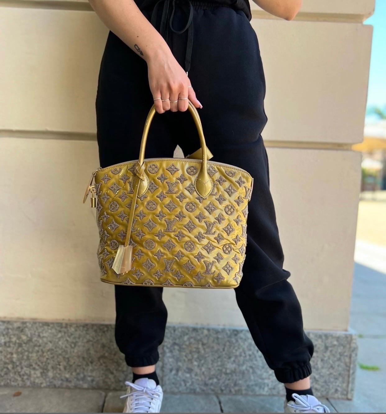 Louis Vuitton lockit model limited edition gray bag, made of yellow ocher patent lambskin and bouclé wool logos.

Clochette and tongue in mother of pearl. Equipped with double leather handle. Zip closure.

Internally lined in leather, very roomy.