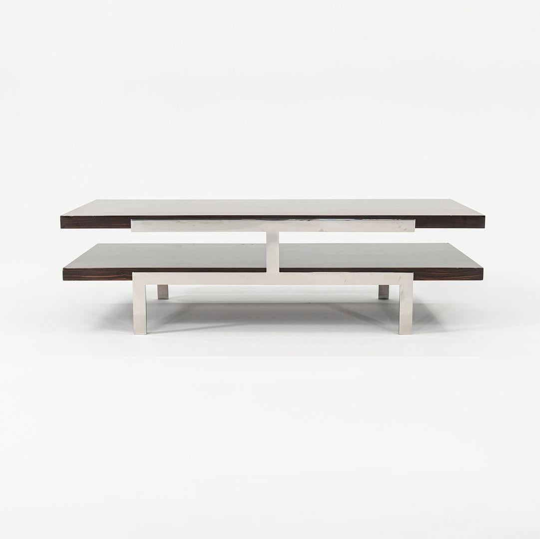 This is an oversized 'Tara' Coffee Table, designed by Deirdre Jordan and Vincente Jimenez of Troscan Design for Holly Hunt. The table dates to 2011. The piece features a top of lush Rosewood, and has a modern highly-polished steel base. 
 
 This