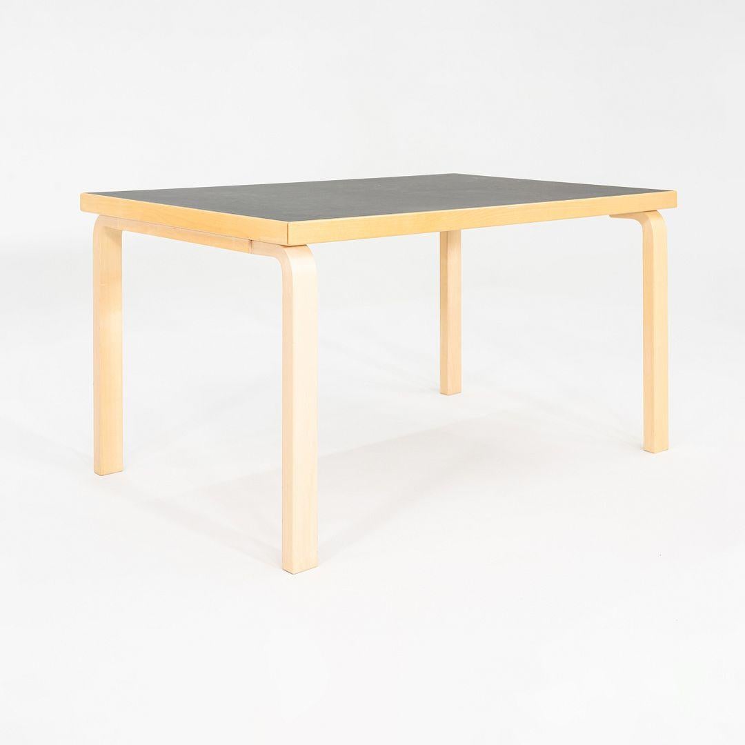 This is a Table 81B, originally designed by Aino and Alvar Aalto in 1935. This particular example was produced by Artek in Finland in 2012. The piece is constructed of steam-bent Birch wood, and its table top is black linoleum. 

The table measures