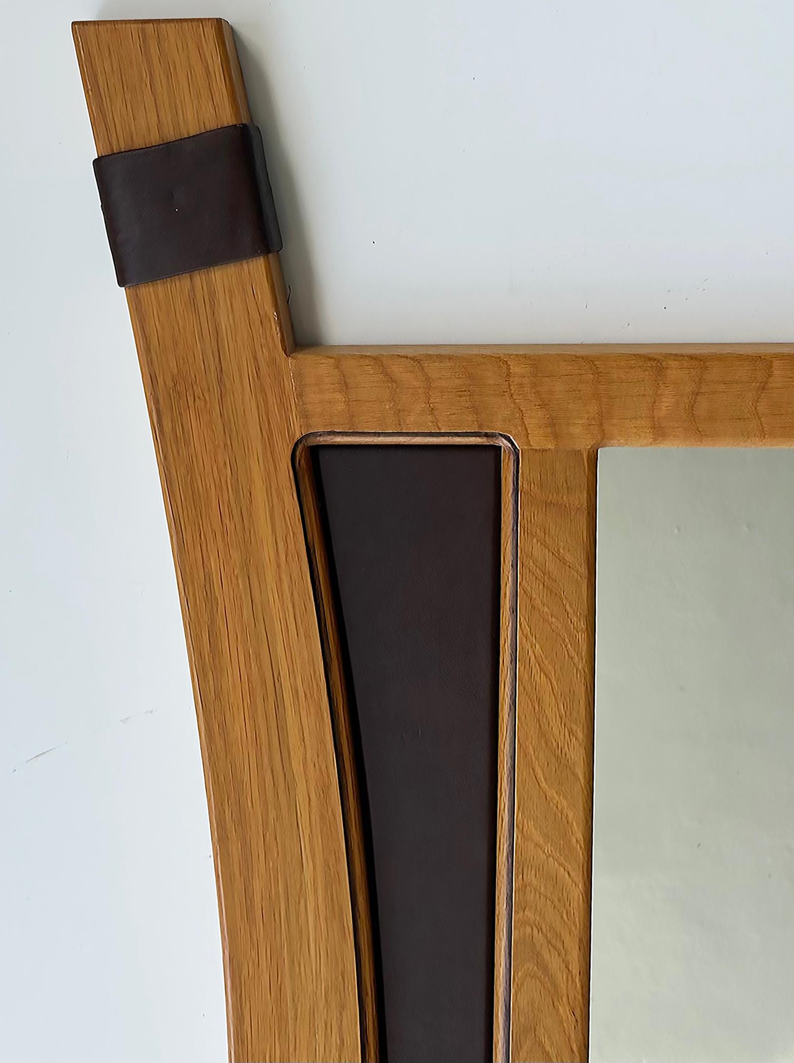 2012 Artist Signed Oak and Leather Studio Crafted Wall Mirror 

Offered for sale is an interesting and unusually shaped oak studio-crafted wall-mounted mirror with inset leather and bund leather accents.  The back of the frame is illegibly twice