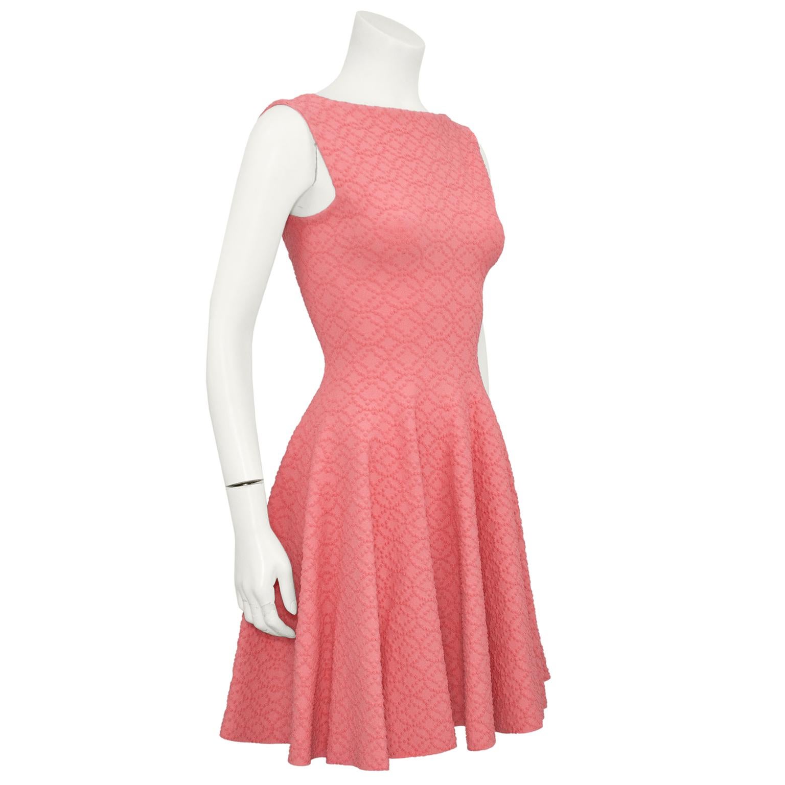 Salmon pink Azzedine Alaia skater dress from 2012. Sleeveless with a boat neckline. Fitted through the body with an aline skirt. The low back contrasts beautifully with the higher neckline in the front. Made in the classic Alaia double stretch knit