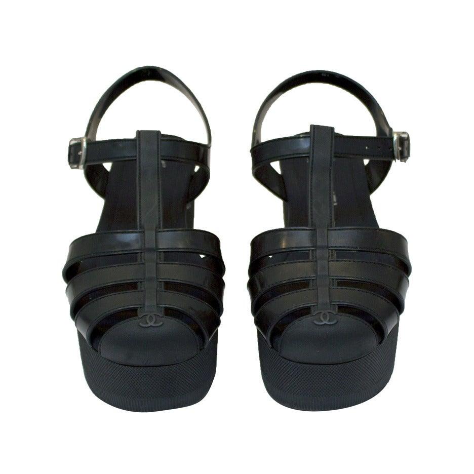Chanel black plastic platform jelly sandals from the Spring 2012 collection. The sandals are styled like a classic jelly sandal of the early 1990's but they have a 2 inch platform and optional neoprene sockette. Silver buckle at the ankle and CC on