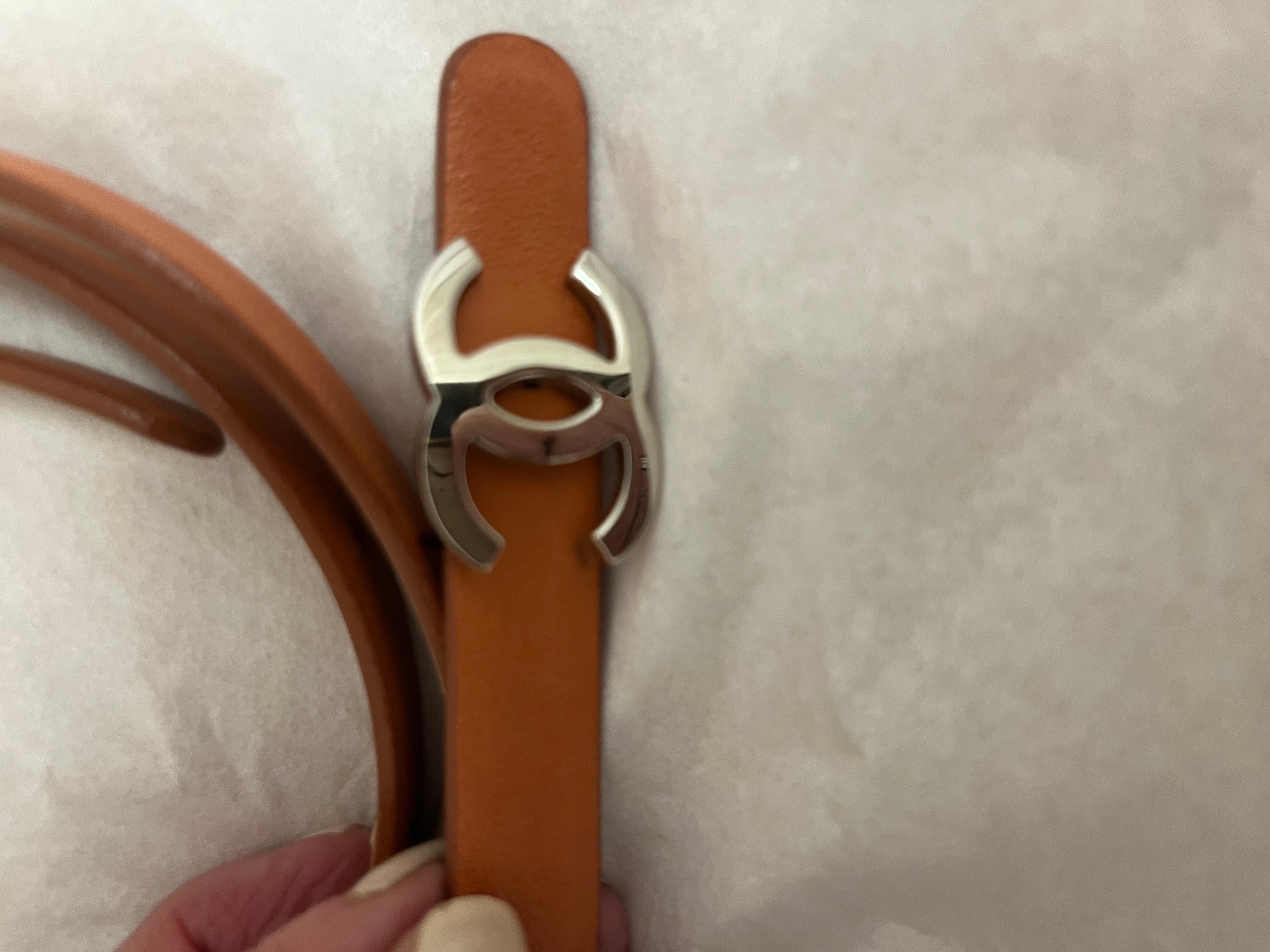 This is a classic accessory from Chanel! The Chanel Coco skinny belt is tan in color which goes with almost any outfit. The belt has a silver-tone interlocking logo buckle (detachable) with peg in hole closure/clasp. There is very little wear on the