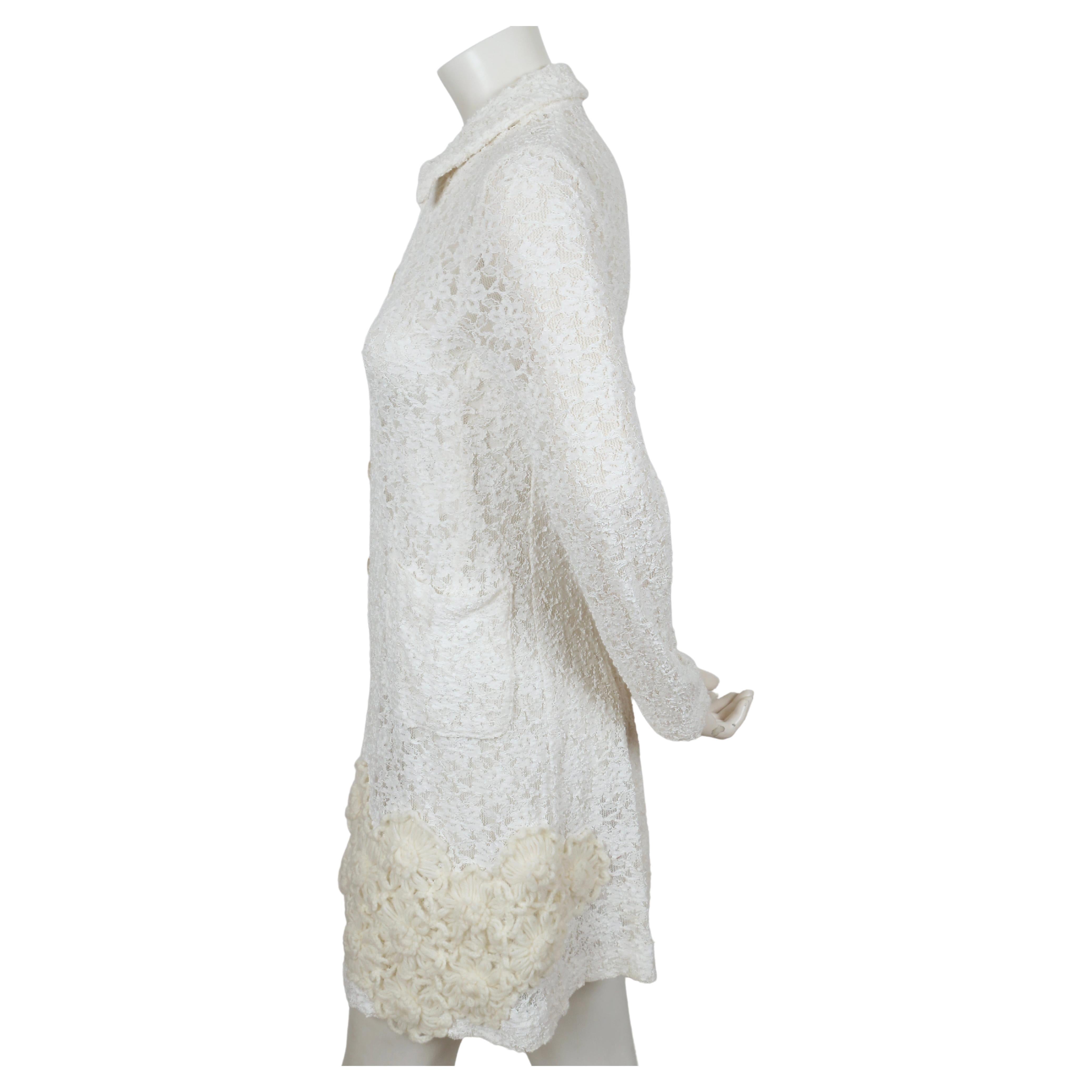 Off-white long lace jacket with cream knit flower detail designed by Rei Kawakubo for Comme Des Garcons dating to spring of 2012. Size 'S'. Best fits a size XS. Approximate measurements (unstretched): shoulder 14
