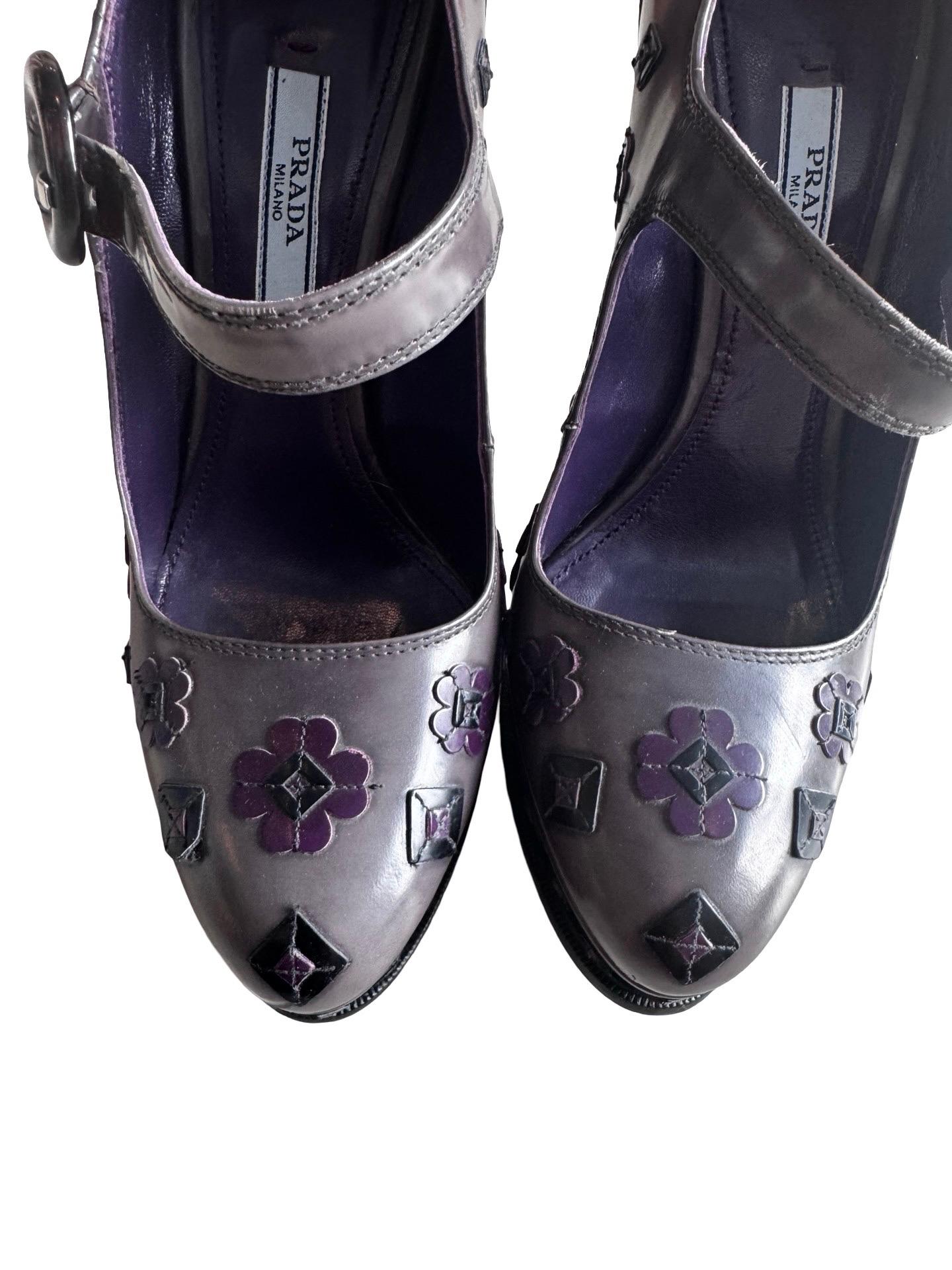 Chaussures à talons compensés automne-hiver 2012 Prada avec bride mary jane et appliques florales et carrées en gris fumé et violet avec carrés noirs.  Fermoir en écaille au niveau de la lanière (légère usure du cuir) et plateforme de 1