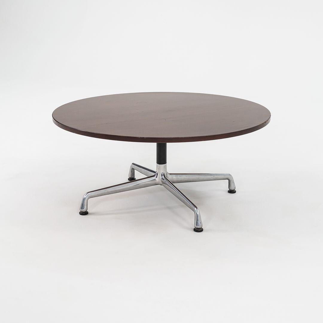 This is an Eames Aluminum Group coffee table designed by Ray and Charles Eames. This particular example was produced by Herman Miller in the USA circa 2012. The table is comprised of an aluminum base with a wood tabletop. The price listed is for one