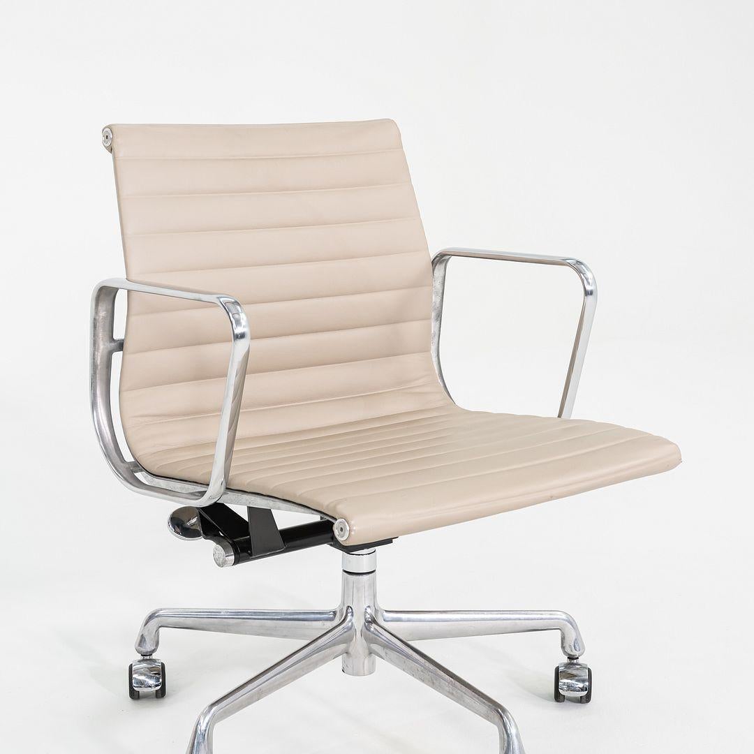 These are Eames Aluminum Group Management Chairs, model EA335, originally designed by Ray and Charles Eames for Herman Miller in 1958. These particular examples were produced in 2012. Their design features a 5-star aluminum base on castors with a