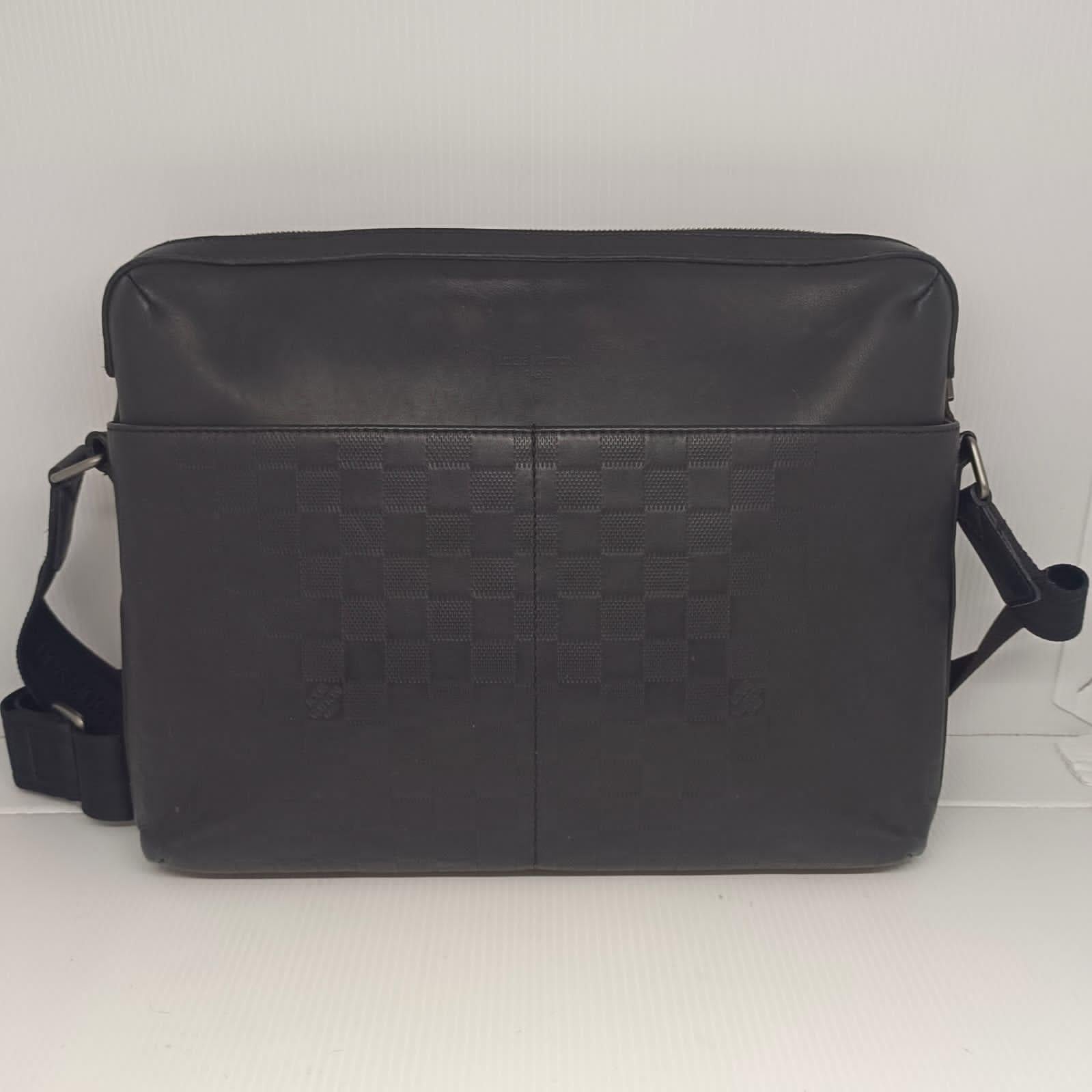 Damier infini calypso mm bag in black leather. Slight signs of wear throughout with faint scratches and scuffs. Faint white marks on the exterior leather. Lining is clean. Comes with its dust bag.