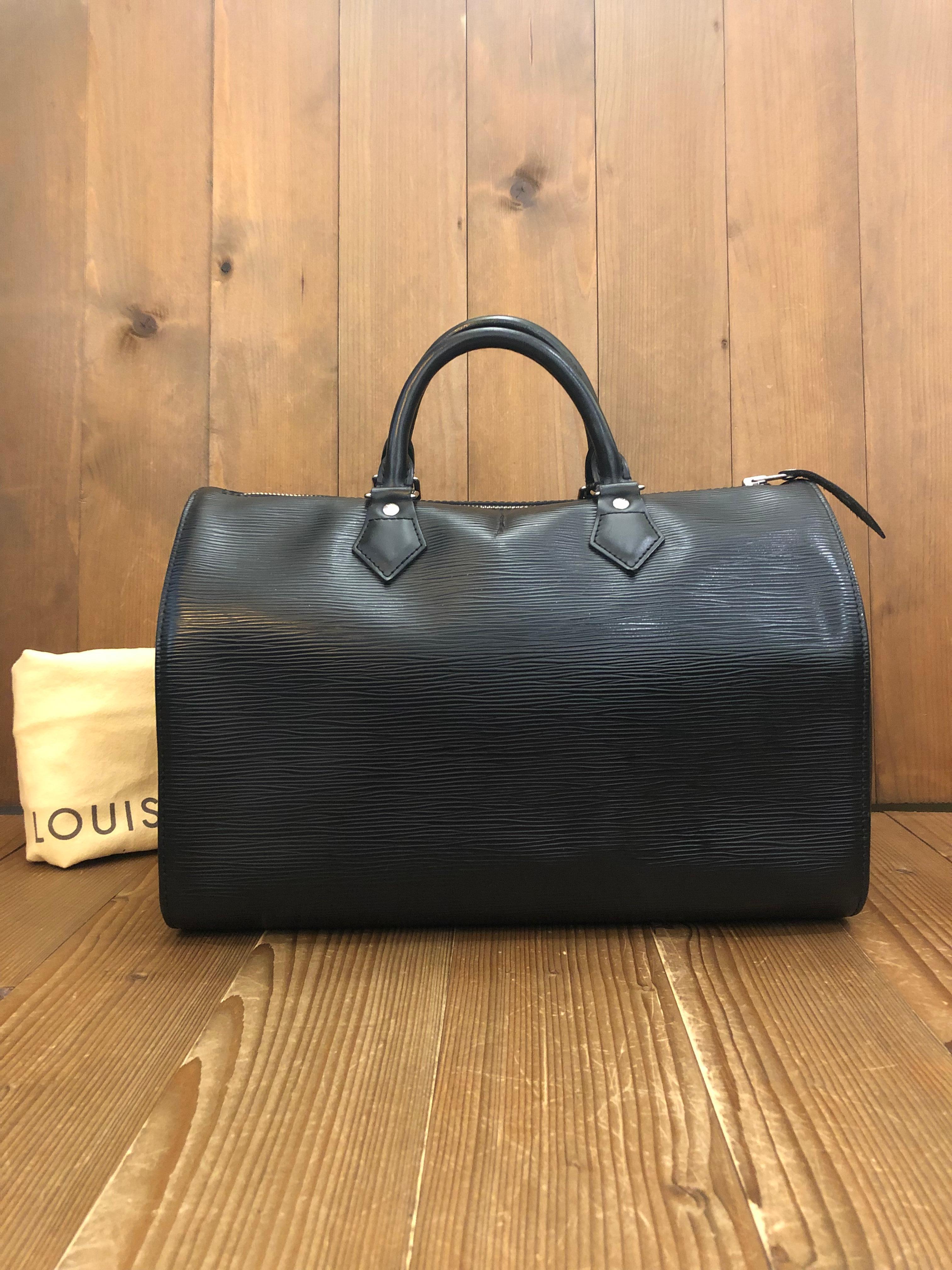 This chic LOUIS VUITTON Speedy 30 boston bag is crafted of Louis Vuitton’s signature Epi leather in black featuring silver hardware. This bag features a side patch pocket and rolled leather handles. Top zipper closure opens to a black fabric