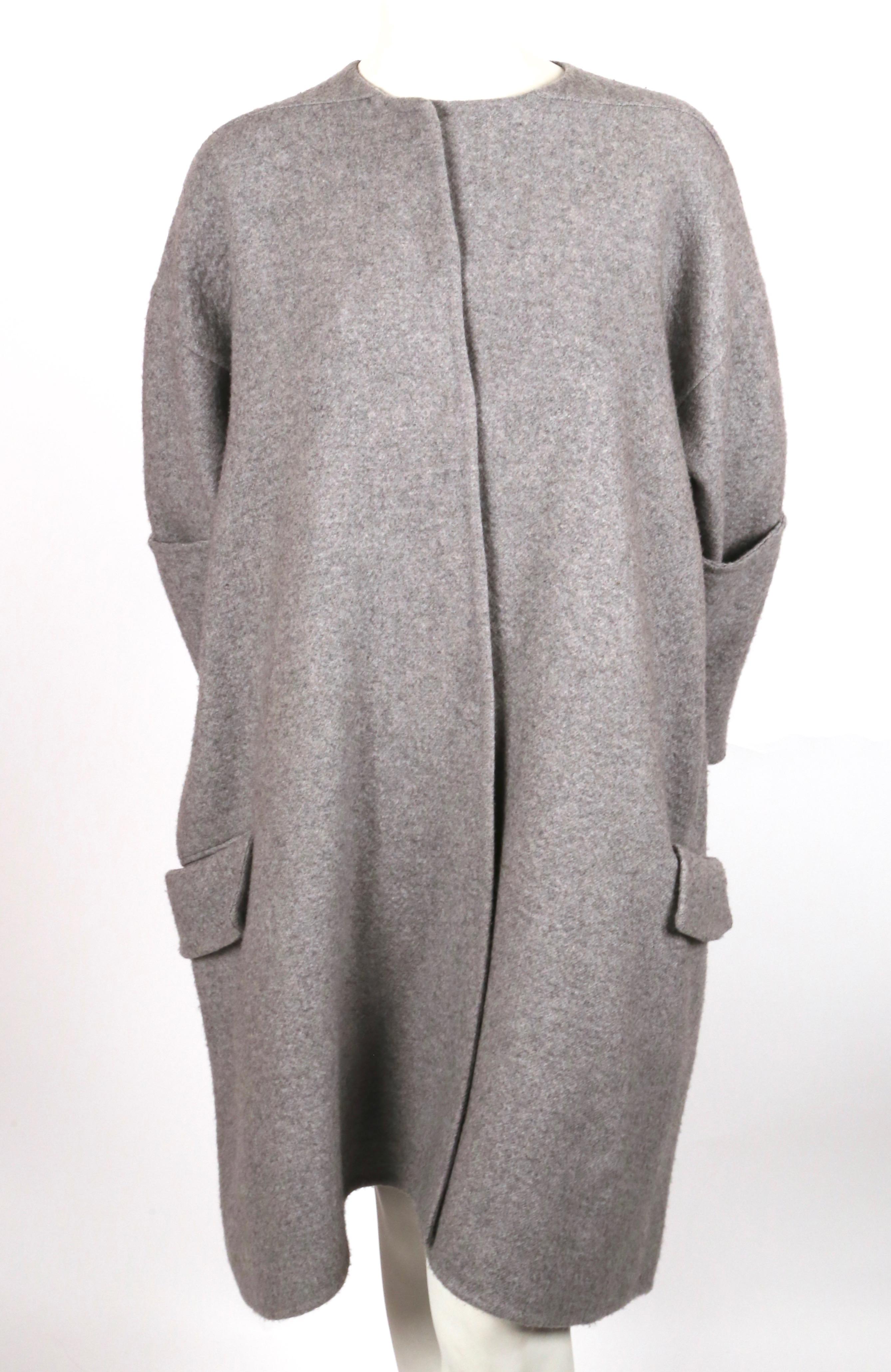 Very rare, grey, double-faced, cashmere coat with exaggerated long sleeves designed by Phoebe Philo for Celine exactly as seen on the runway. Underneath the arms, there are openings to slide arms through so sleeves can be knotted at front as shown