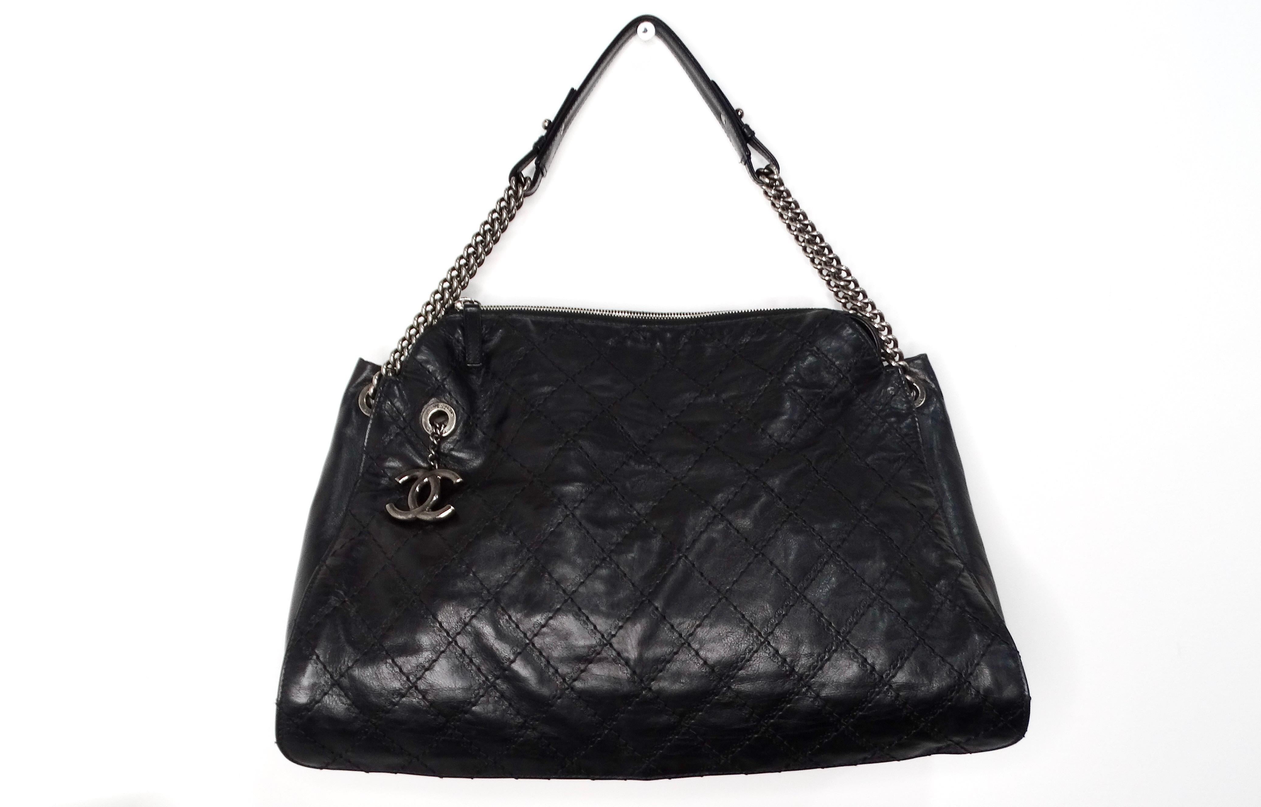 La borsa Chanel Black CC Crave Quilted Calfskin Hobo Tote 2013 è un pezzo straordinario che incarna lusso e raffinatezza. Realizzata in pelle di vitello di alta qualità, questa tote hobo presenta piccoli loghi CC in rilievo intorno alle cuciture,