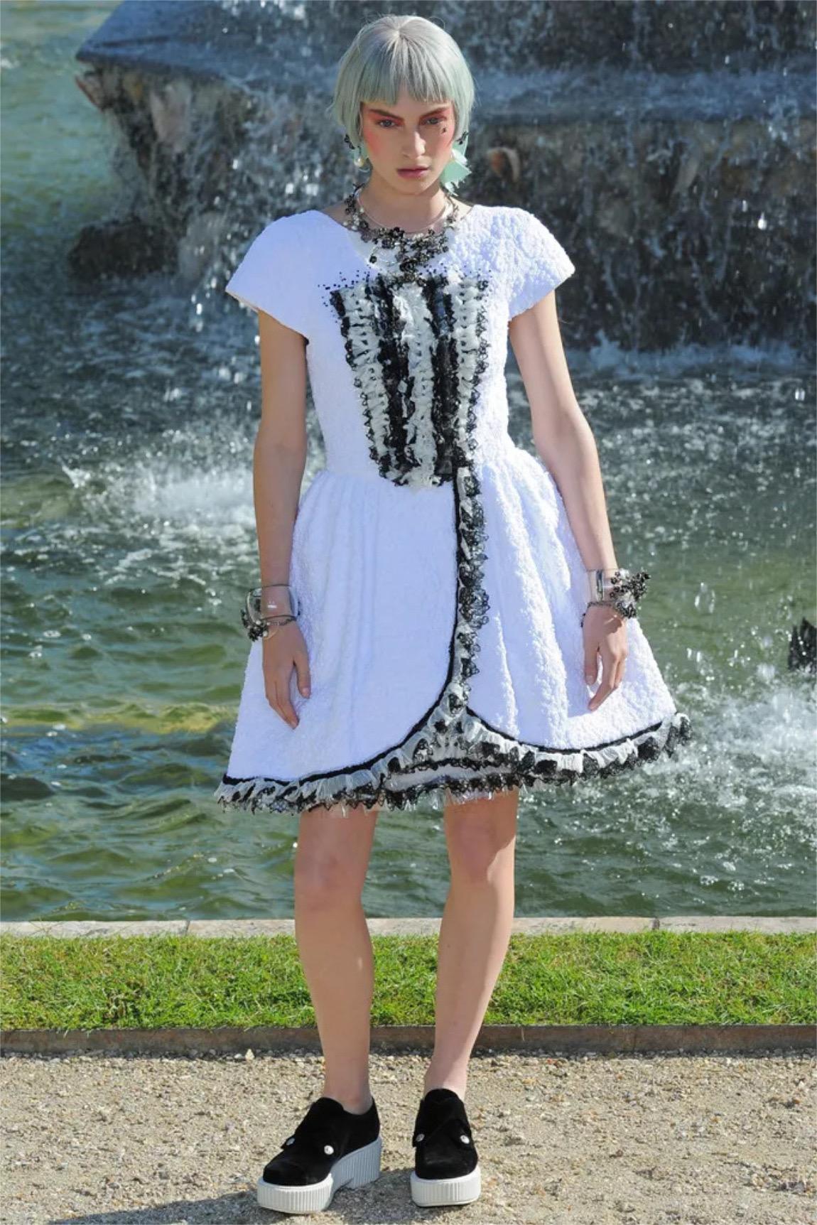Una muestra de pasarela de Chanel increíblemente chic y muy codiciada, un vestido de seda blanca texturizada con lujosos detalles de volantes que data de la adorada colección crucero 2013 de Karl Lagerfeld. Este rarísimo vestido era el look número