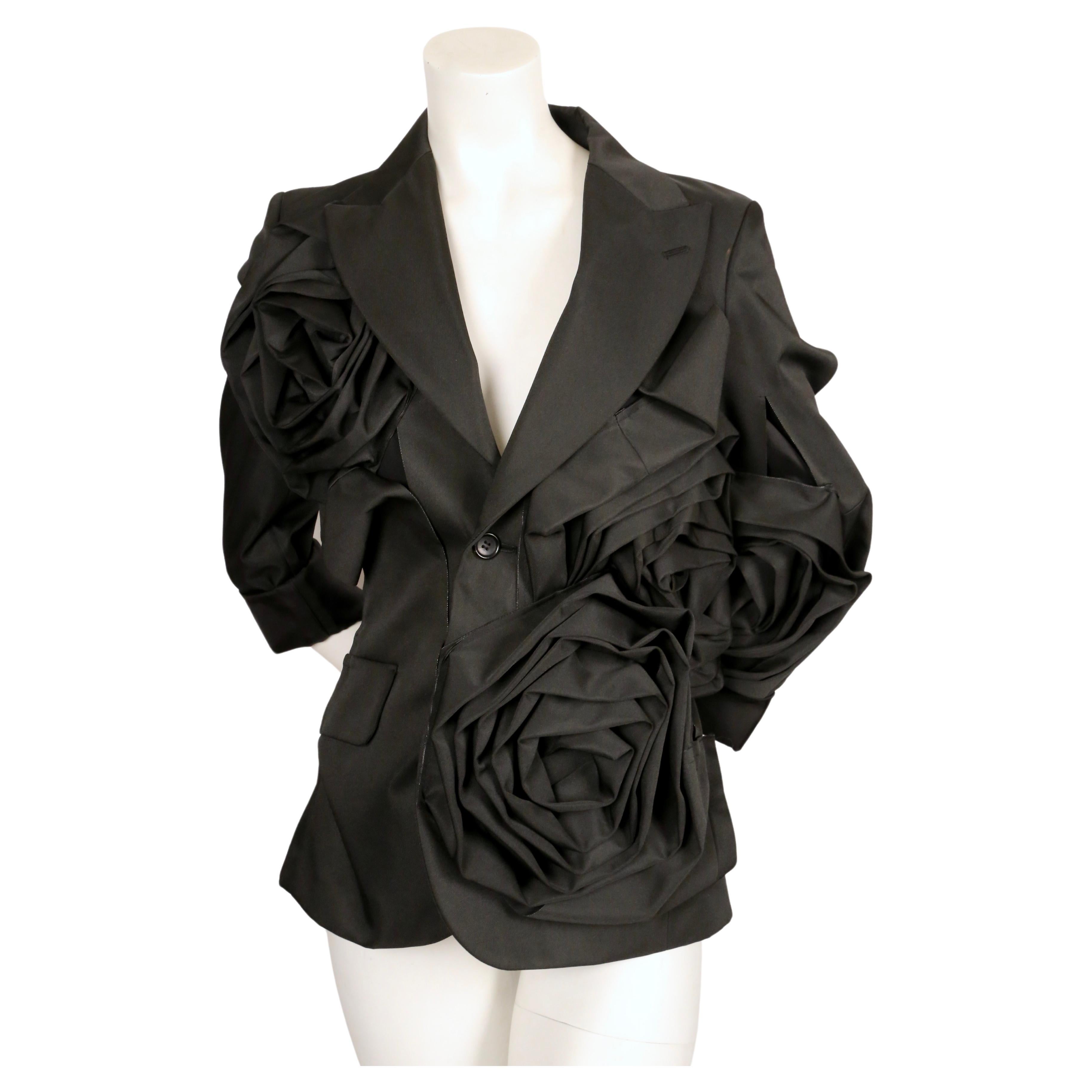 Very dramatic asymmetrical black jacket with oversized rose motif and cut outs designed by Rei Kawakubo for Comme Des Garcons exactly as seen on the fall 2013 runway.  Labeled a size 'S'. Approximate measurements: shoulder 16.25
