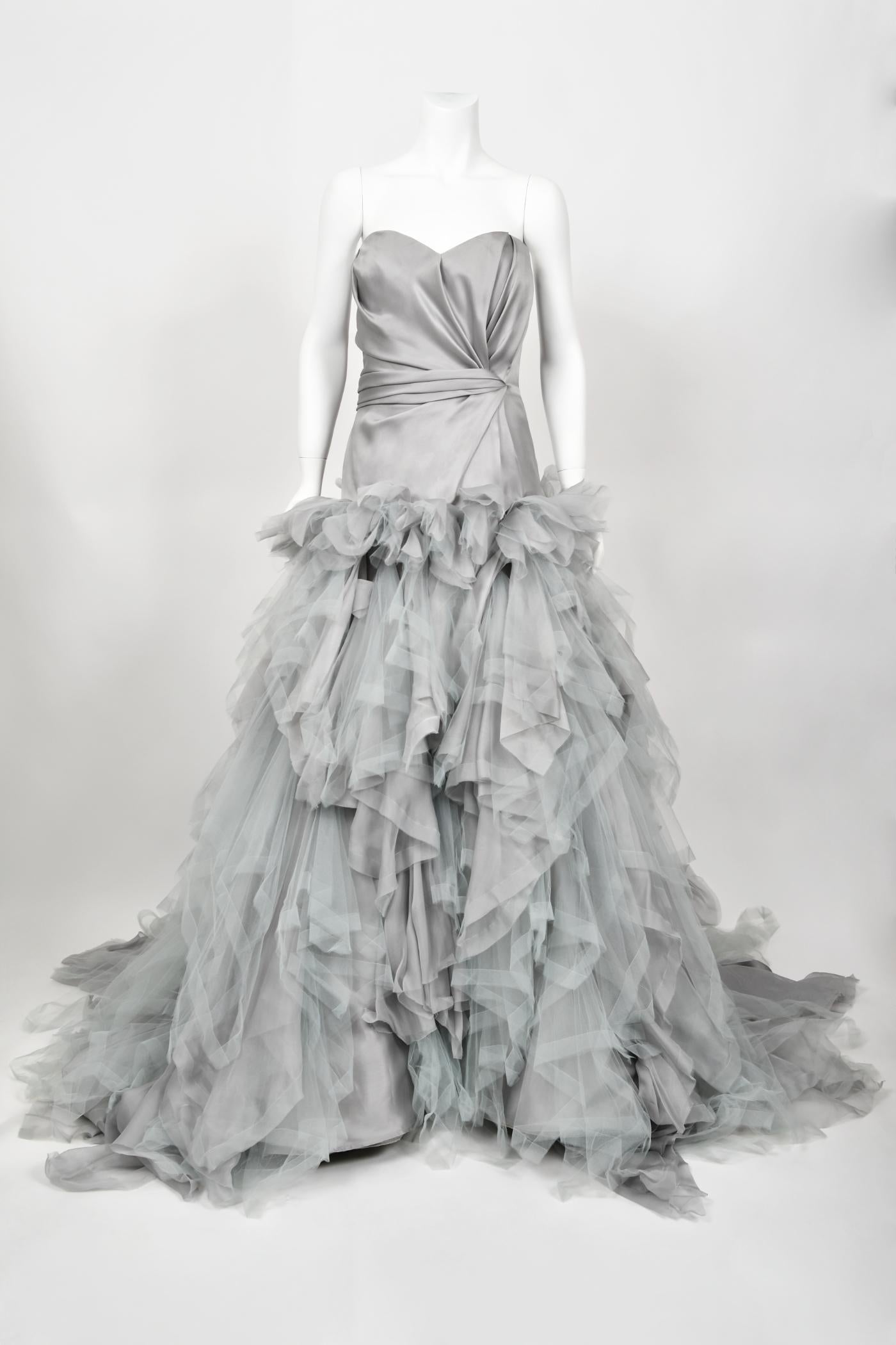 A truly magnificent, unworn with tags Oscar de la Renta dove-grey silk and tulle bustier strapless tiered ballgown dating back to his 2013 resort collection. As shown, the stunning Emma Watson wore a very similar dove-gray gown for the London