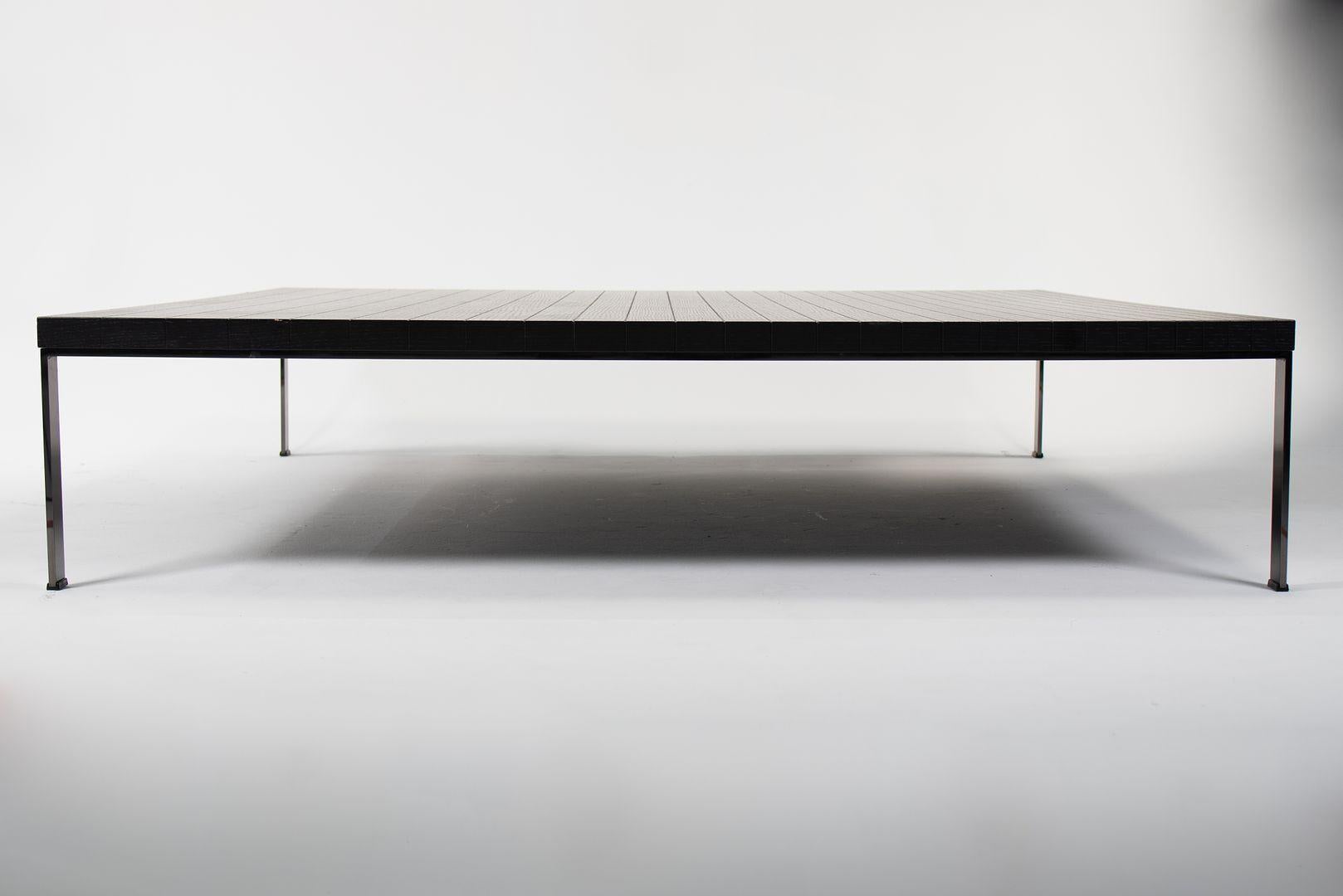 This is a low Geometrie Coffee Table by Poltrona Frau. The piece was manufactured in Italy in 2013. It is formed of ebonized open-pore wenge wood, and has steel legs. The scored geometric pattern on the top‚Äôs surface gives a sense of order and