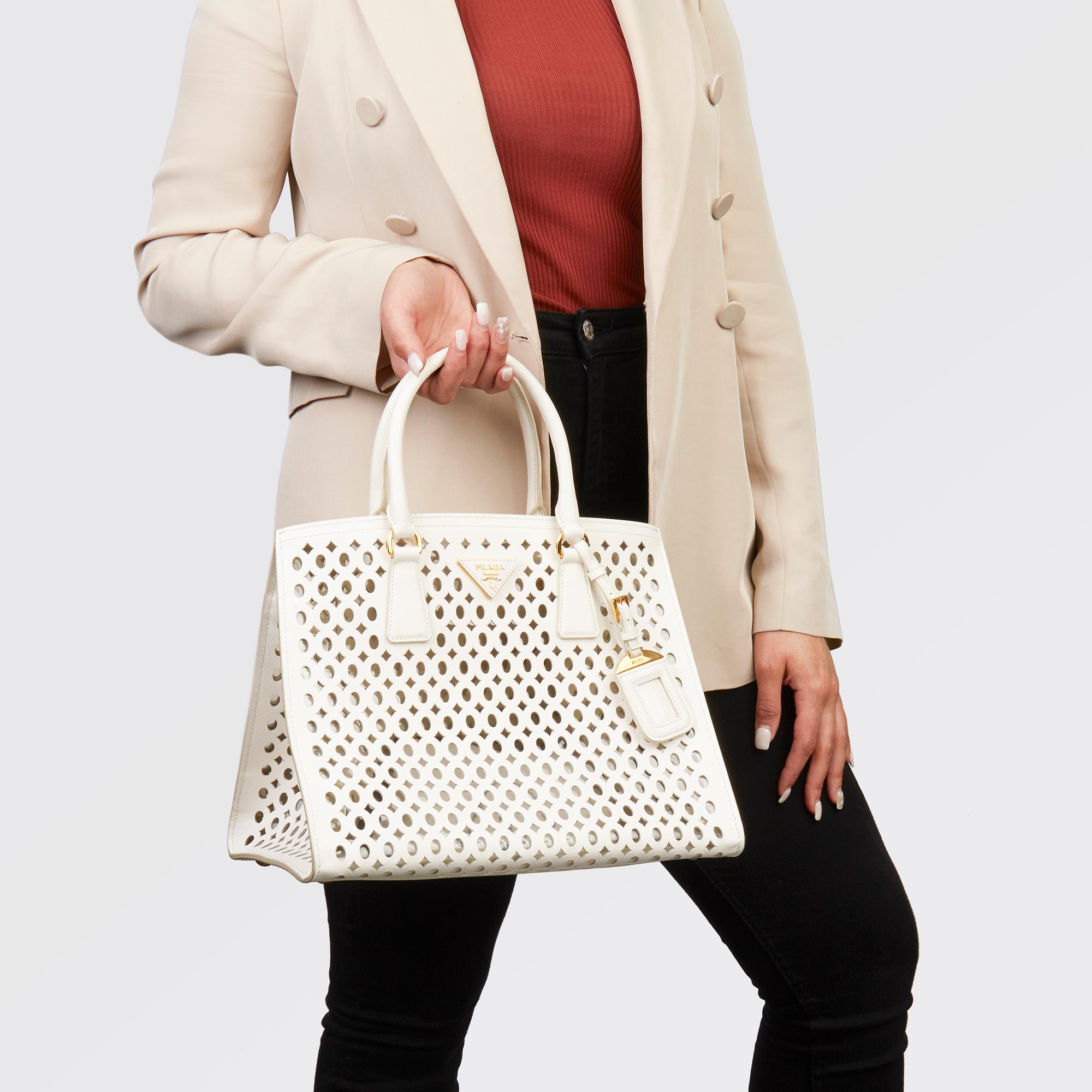 PRADA
White Perforated Saffiano Leather & PVC Fori Tote

Xupes Reference: HB3542
Serial Number: 25
Age (Circa): 2013
Accompanied By: Prada Dust Bag, Prada Invoice
Authenticity Details: Date Stamp (Made in Italy)
Gender: Ladies
Type: Top