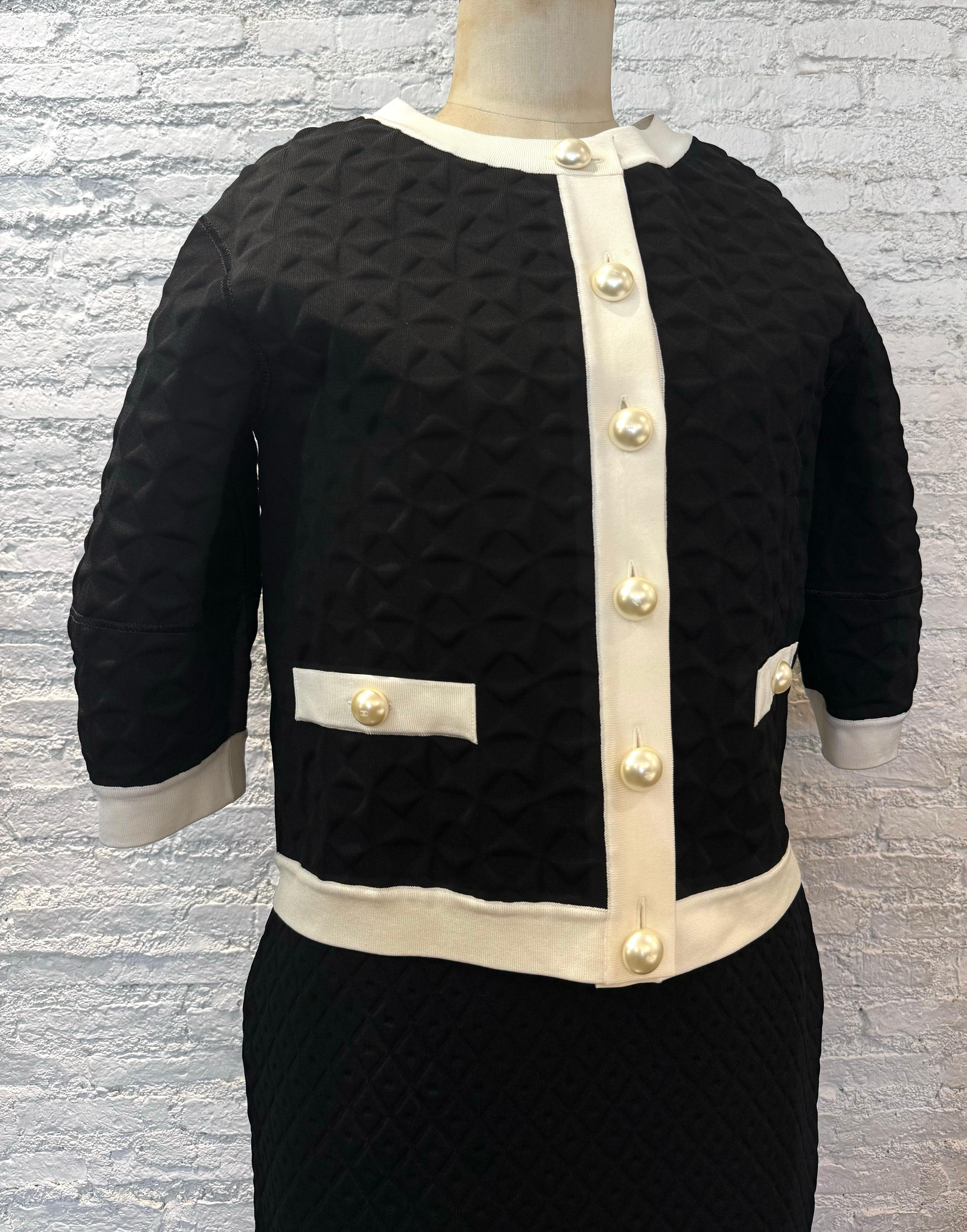 This 2013 Spring Summer CHANEL balloon jacket is crafted of black rayon/polyester textile pressed in windmill pattern with white trims featuring faux pearl buttons and two front faux pockets. This top is from 2013 Spring Summer Powered by Renewable