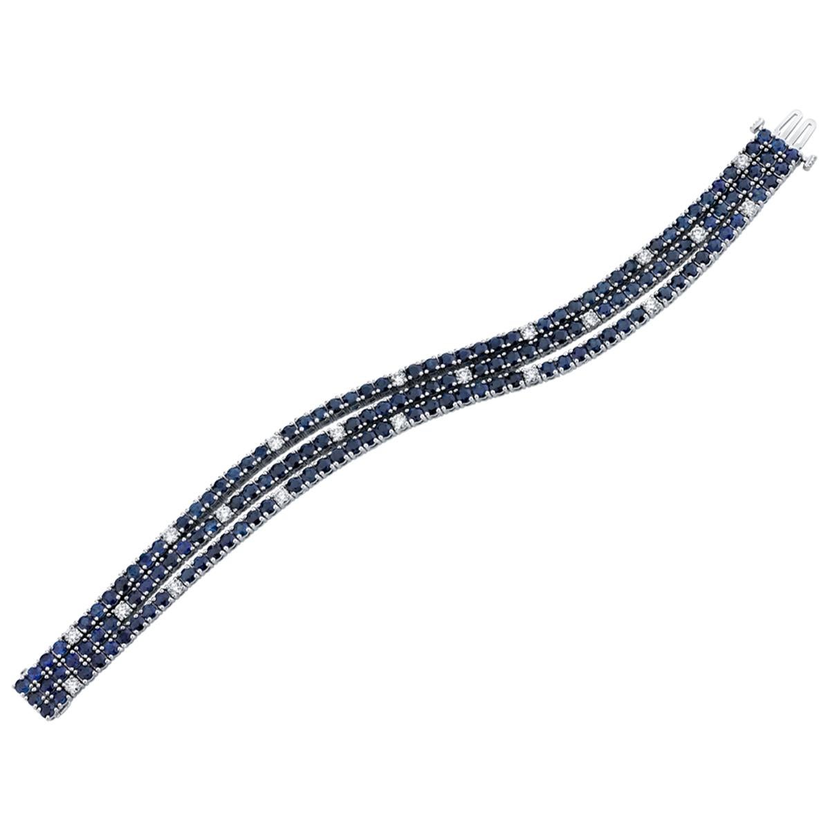 This pretty Art Deco inspired bracelet features royal blue sapphires and round brilliant cut diamonds set in a triple strand of tennis bracelets for an ultra-luxurious look! The blue sapphires have gorgeous color, and nearly two carats of round