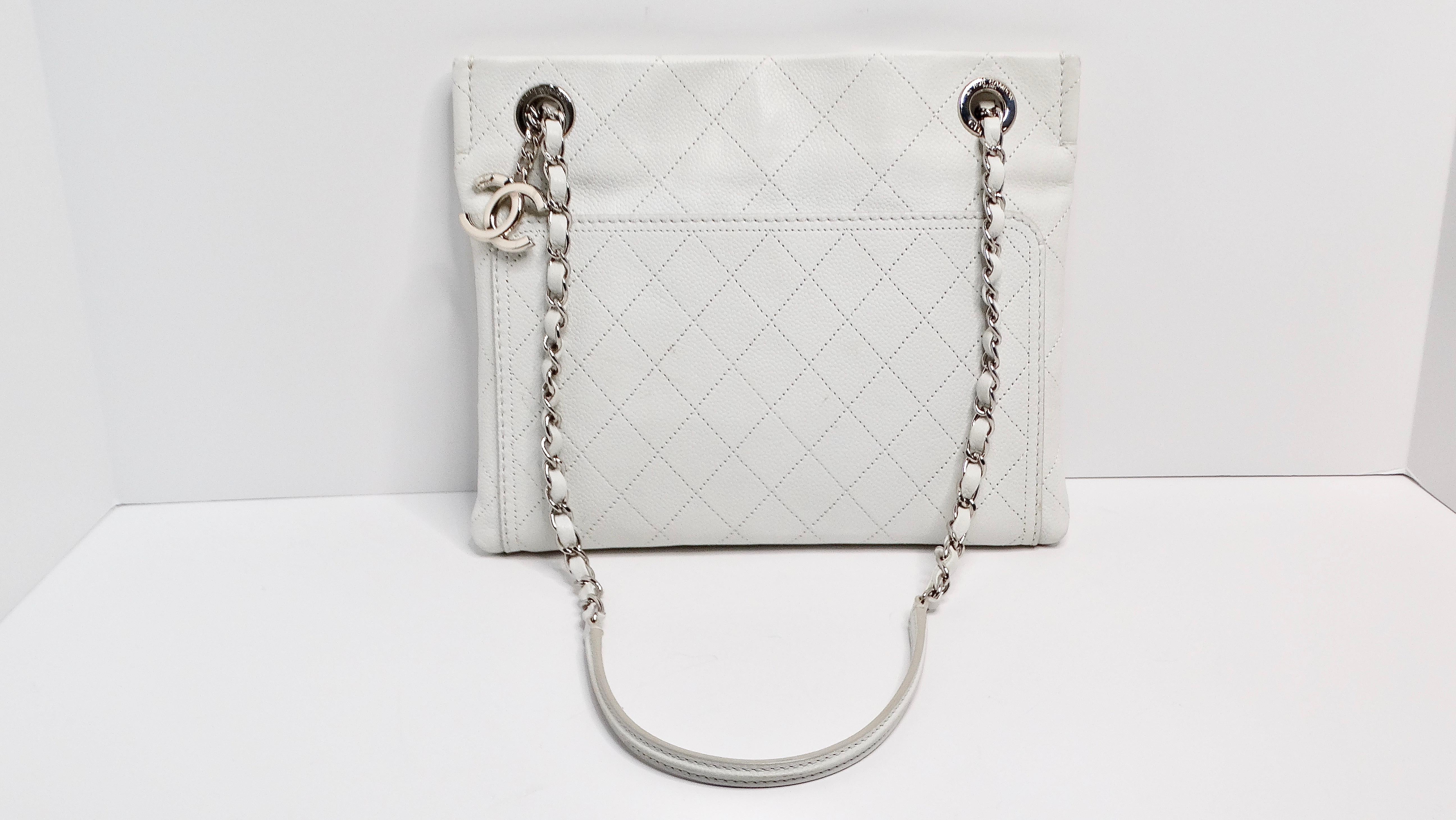 The 2014 Chanel Small CC Pocket Tote, designed under the creative direction of Karl Lagerfeld, epitomizes timeless elegance with a modern twist. Crafted from durable quilted off white caviar leather, this tote features silver-tone hardware and dual