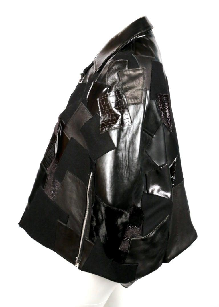 Tonal-black, patchwork poncho with silver hardware designed by Junya Watanabe exactly as seen on the fall 2014 runway. Japanese size S. Approximate length: 26