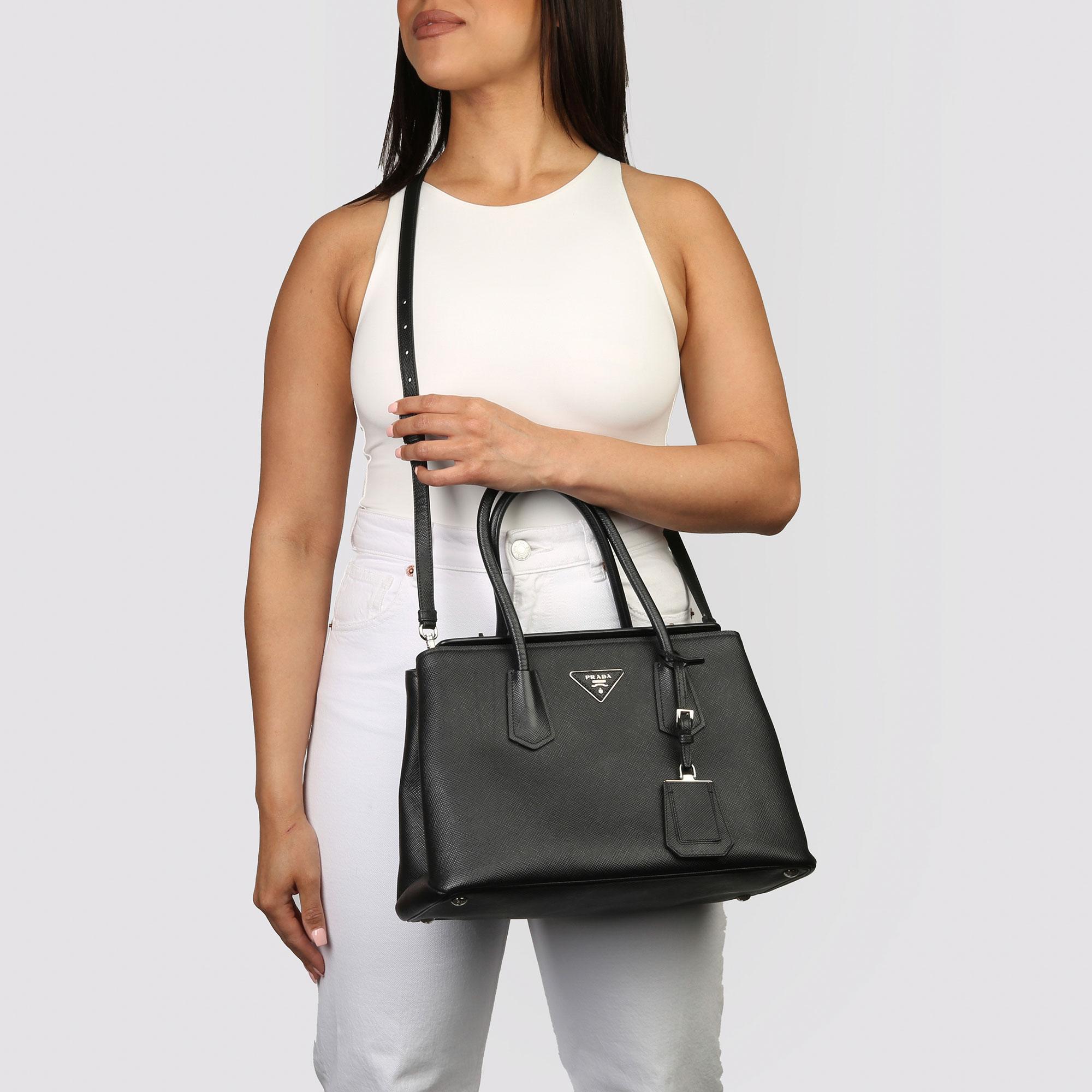 PRADA
Schwarzes Kalbsleder Saffiano Tote

Xupes Referenz: CB338
Seriennummer: 113
Alter (ca.): 2014
Begleitet von: Prada Staubbeutel:: Authentizität Karte:: Pflegeheft:: Schultergurt 
Authentizität Details: Echtheitskarte:: Datumsstempel (Made in